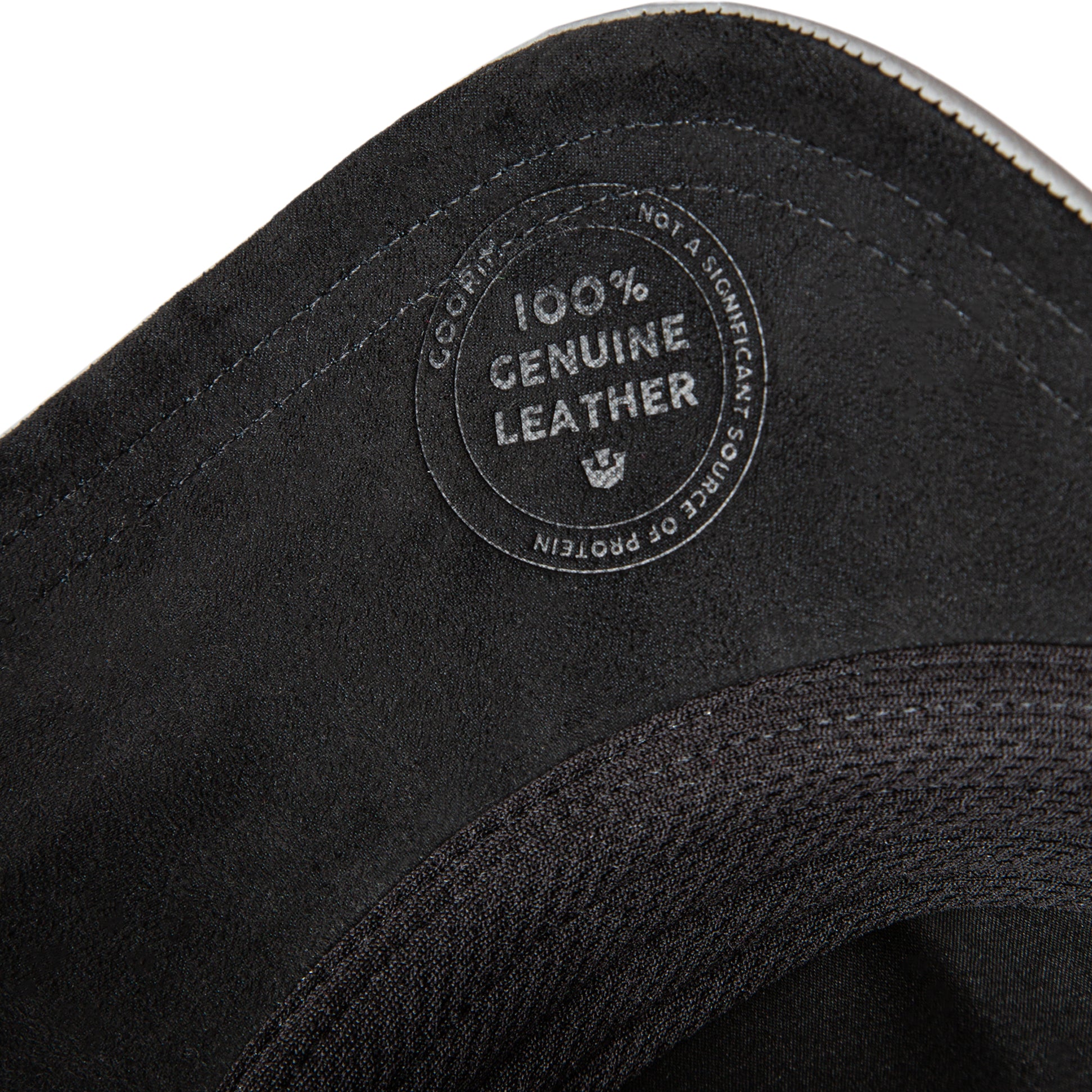Close-up of black leather with a '100% Genuine Leather' label on a white background