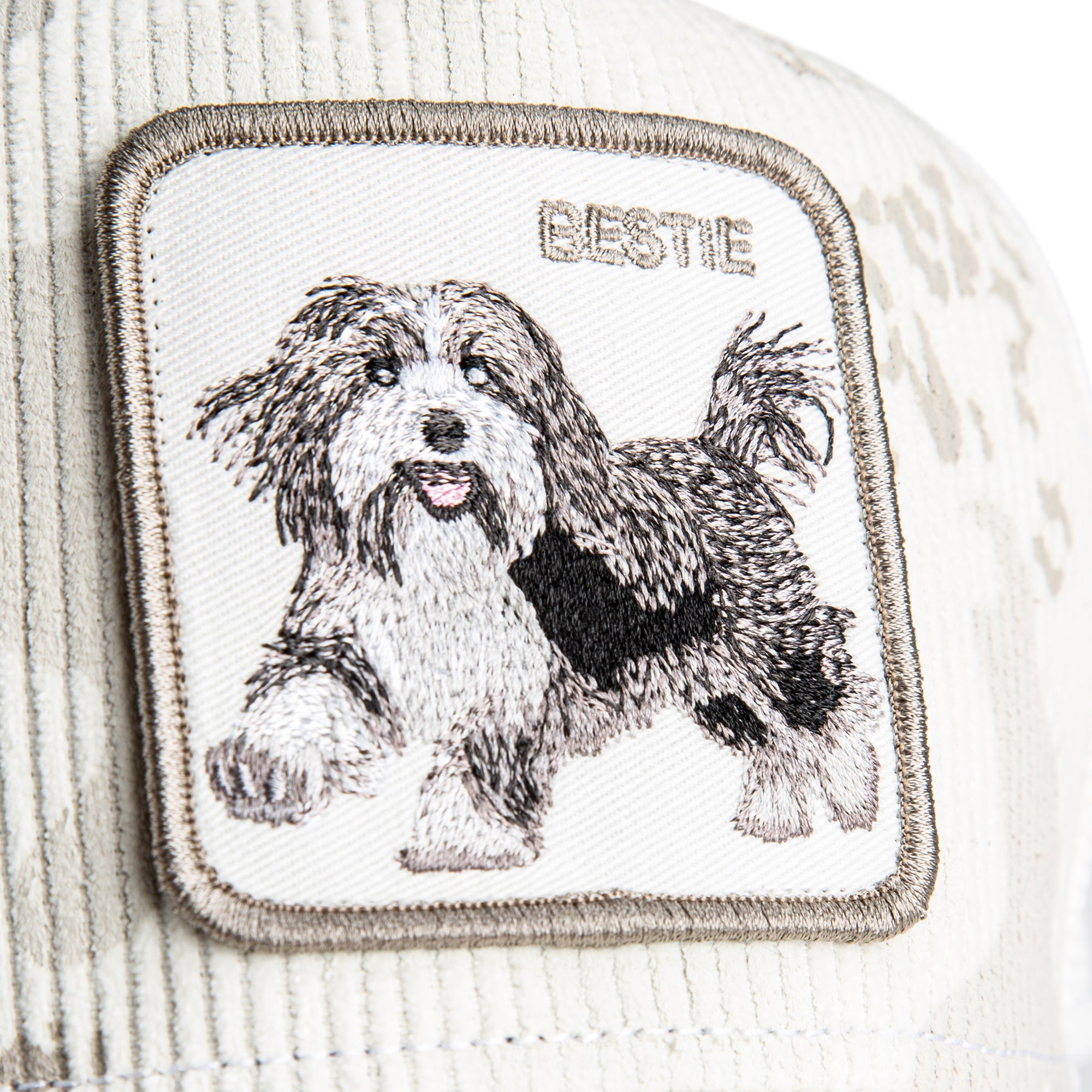 Embroidered patch of a dog with 'BESTIE' text on a textured fabric background
