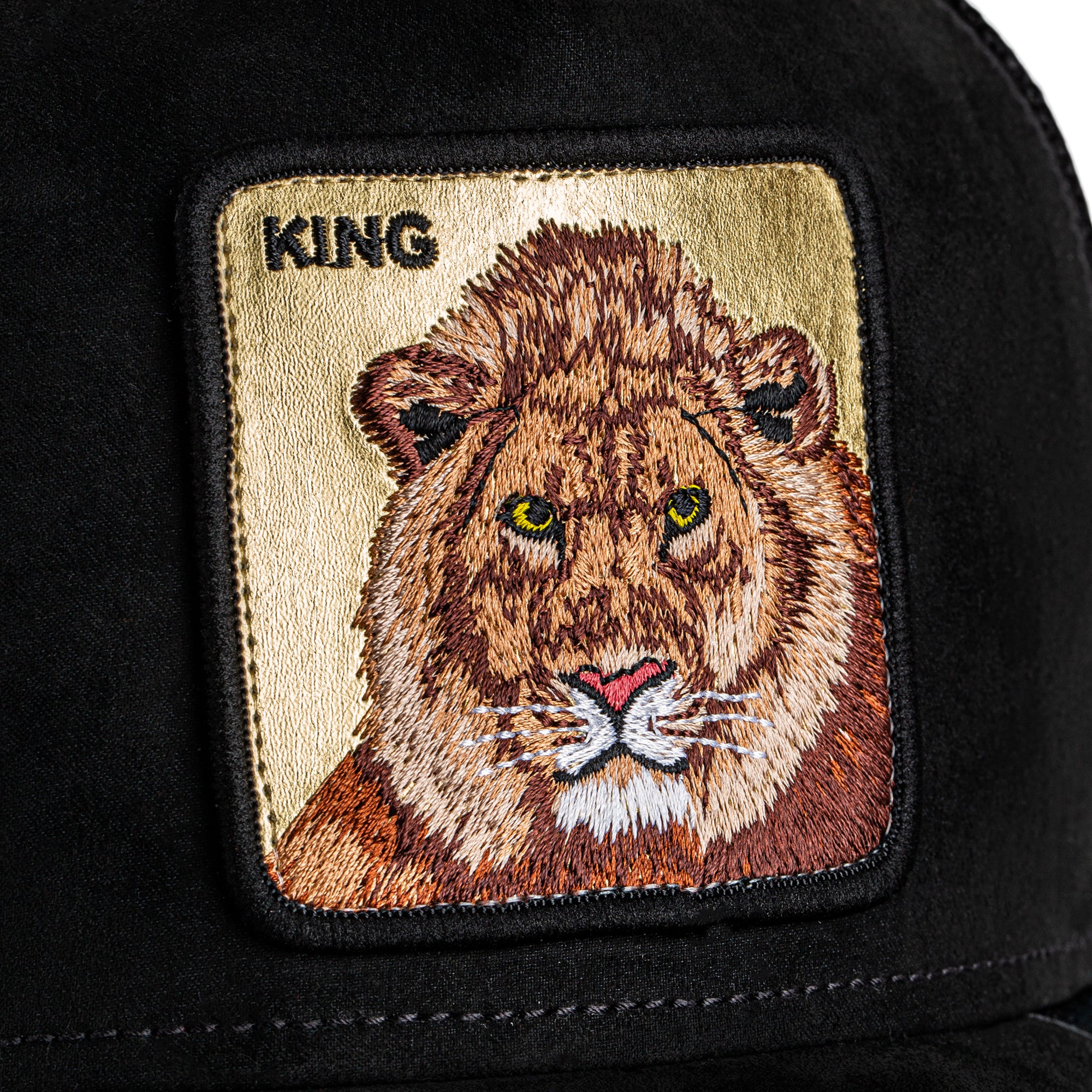 Black cap with a lion patch and 'KING' text on a beige background