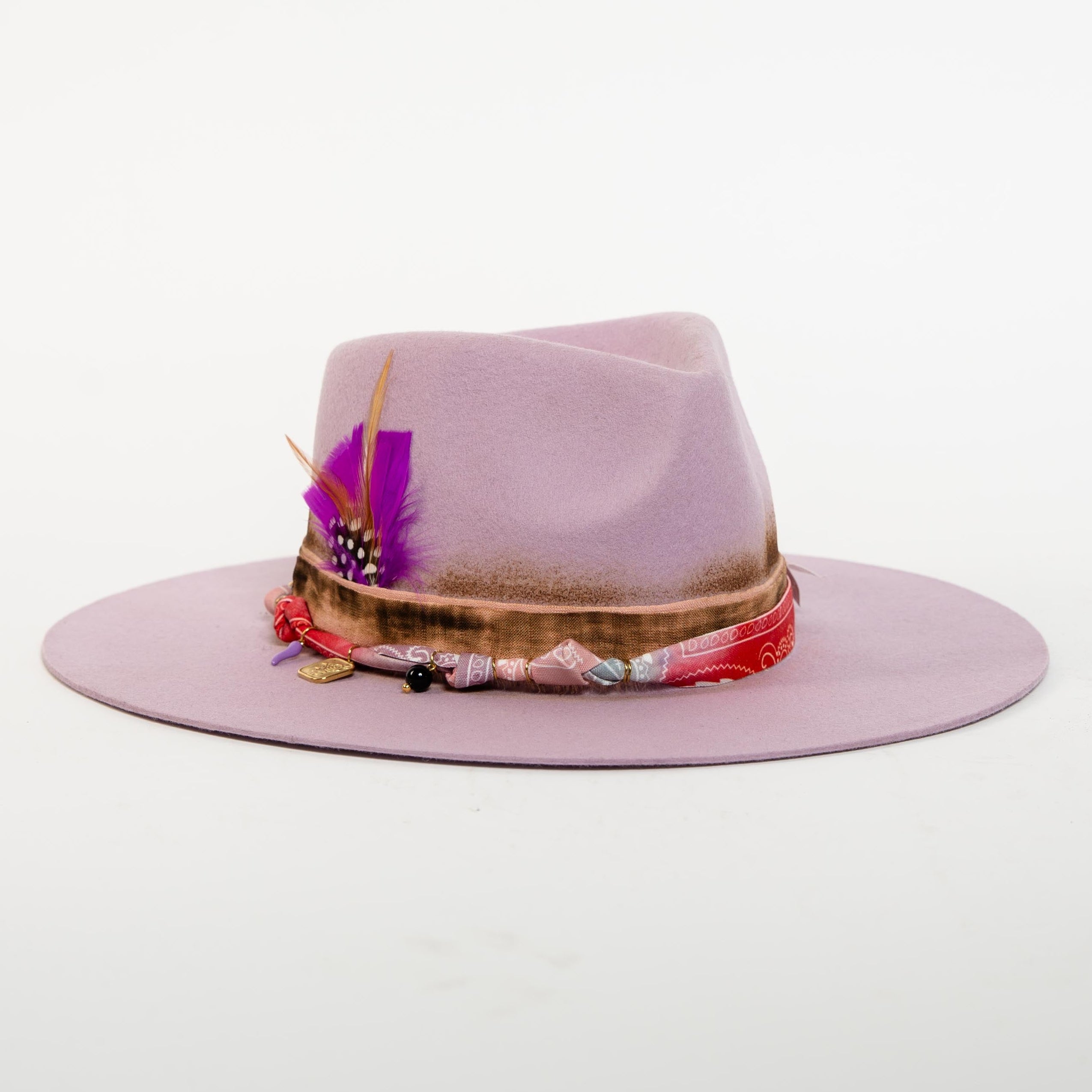 Pink hat with decorative band on a white background