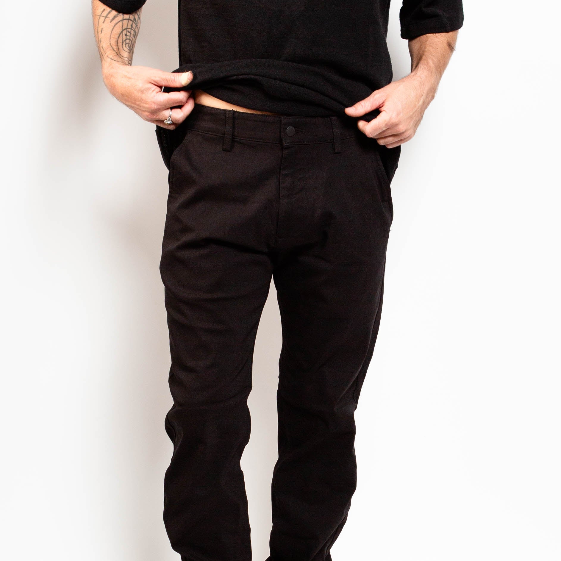 Person wearing black pants against a white background By Projek Raw