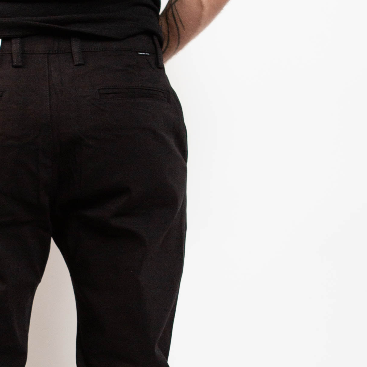 Black pants worn by a person on a white background By Projek Raw