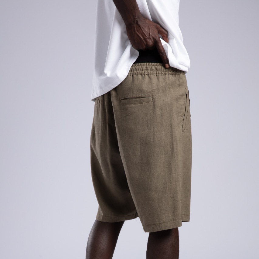 Person wearing beige shorts on a plain background