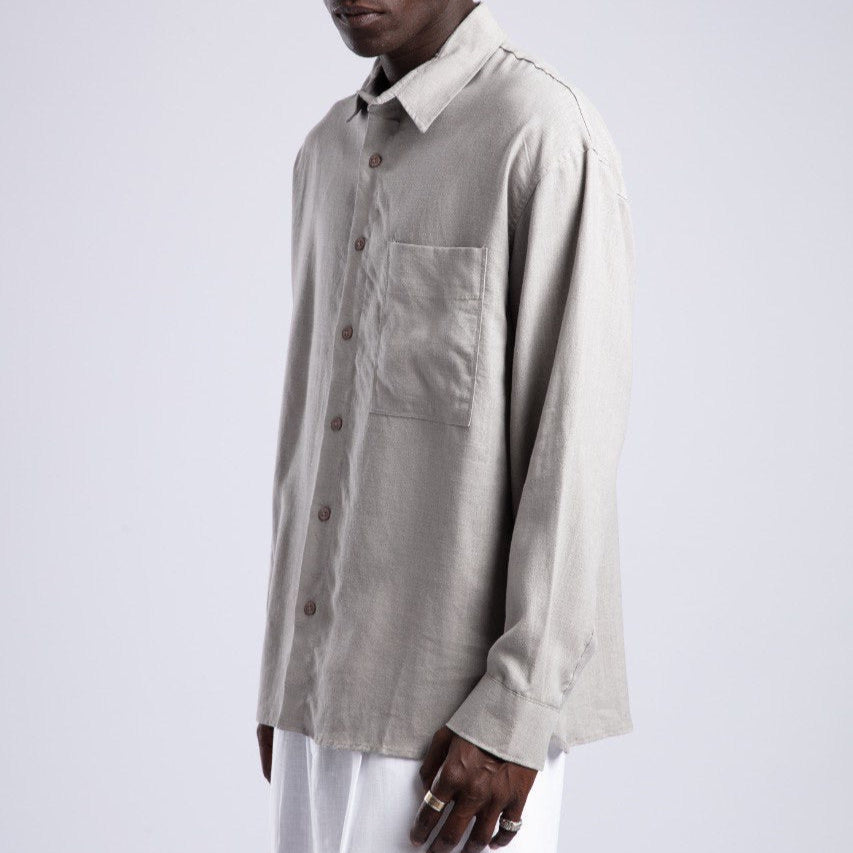 Man wearing a beige shirt and sunglasses on a white background