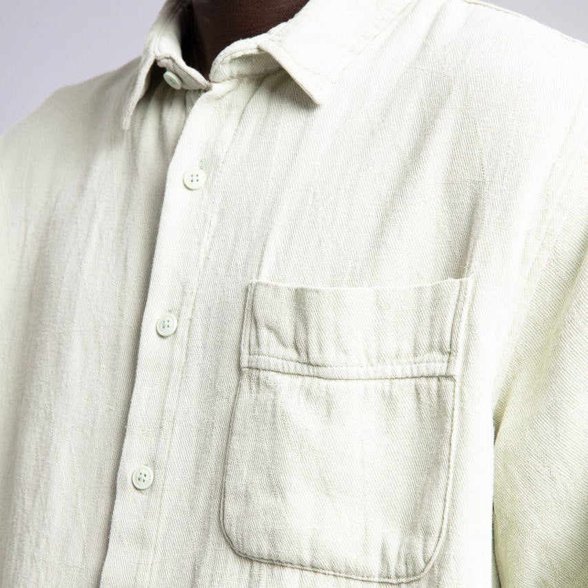 Light-colored shirt worn by a person on a plain background