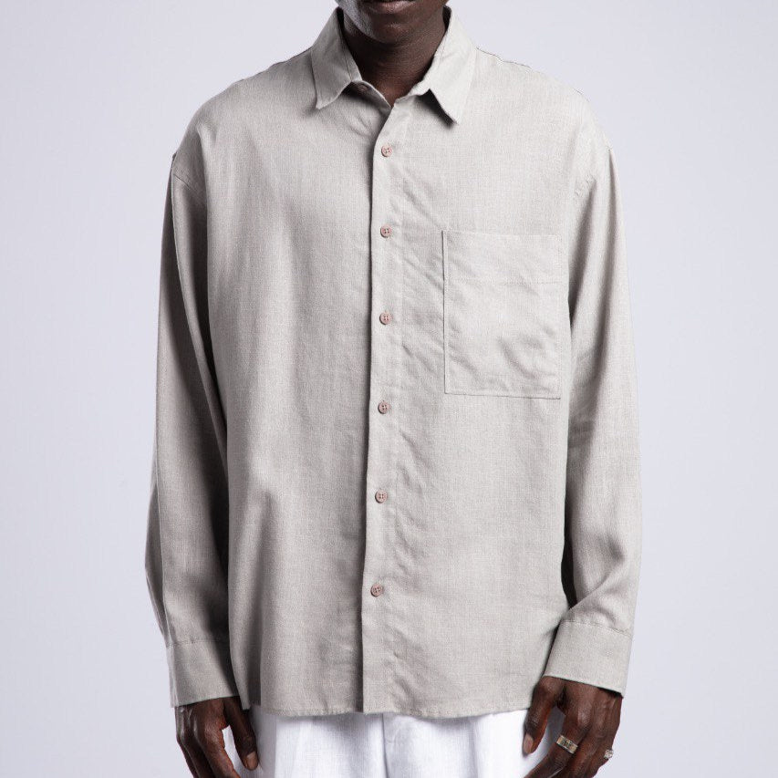 Man wearing a beige shirt and sunglasses on a white background