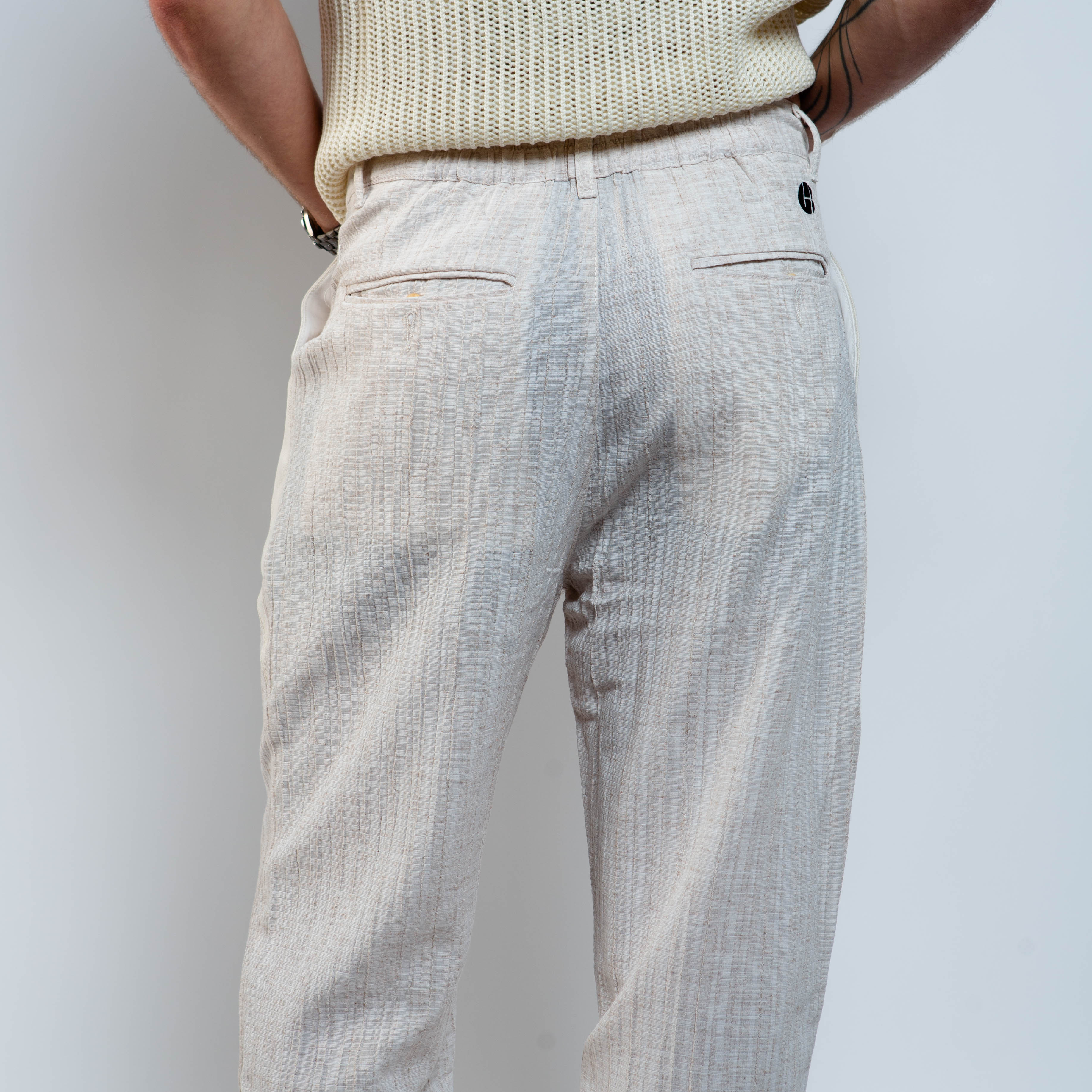 Light-colored pants worn by a person against a plain background