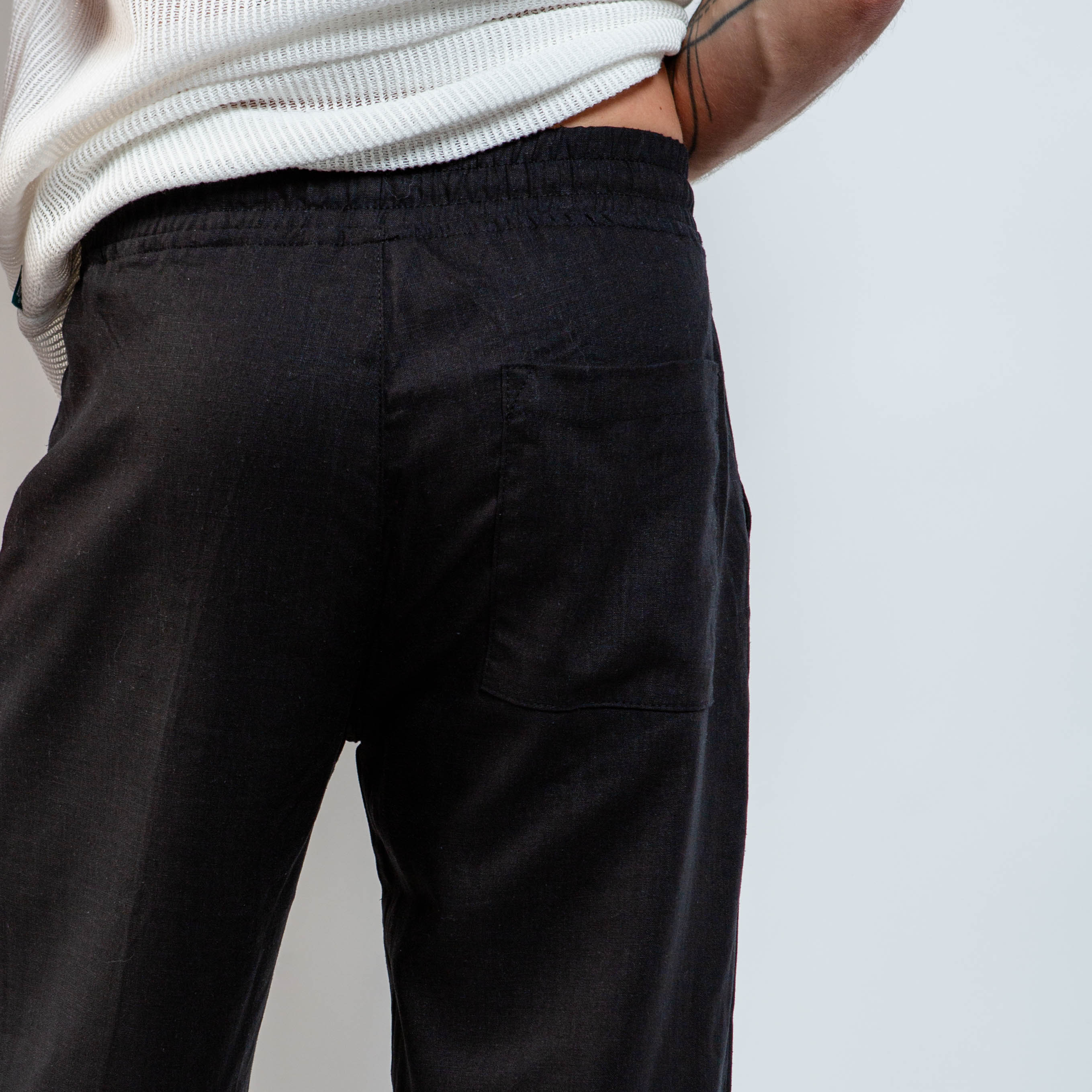 Black pants worn by a person on a plain background