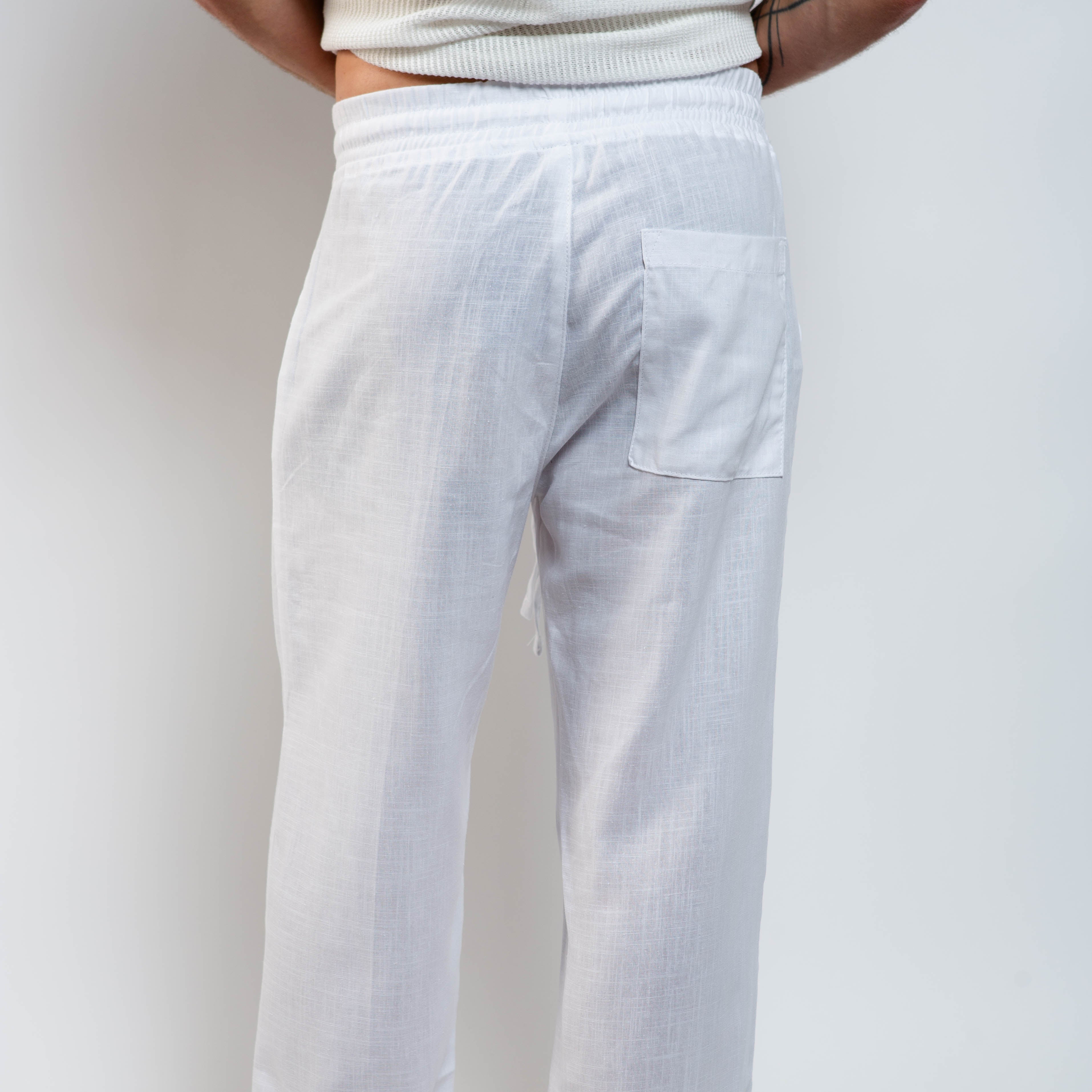White pants worn by a person on a plain background