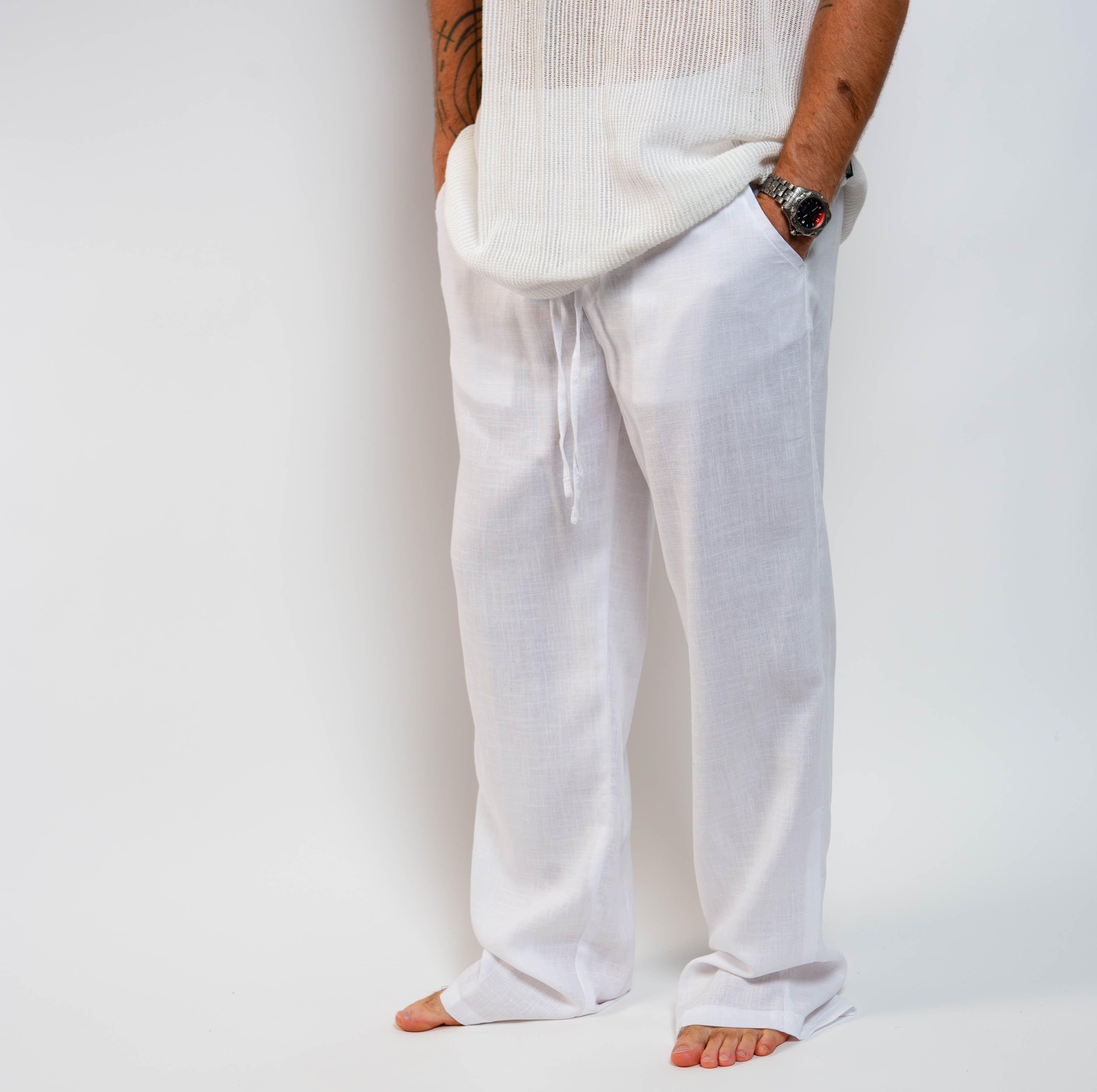 Person wearing white pants on a plain background