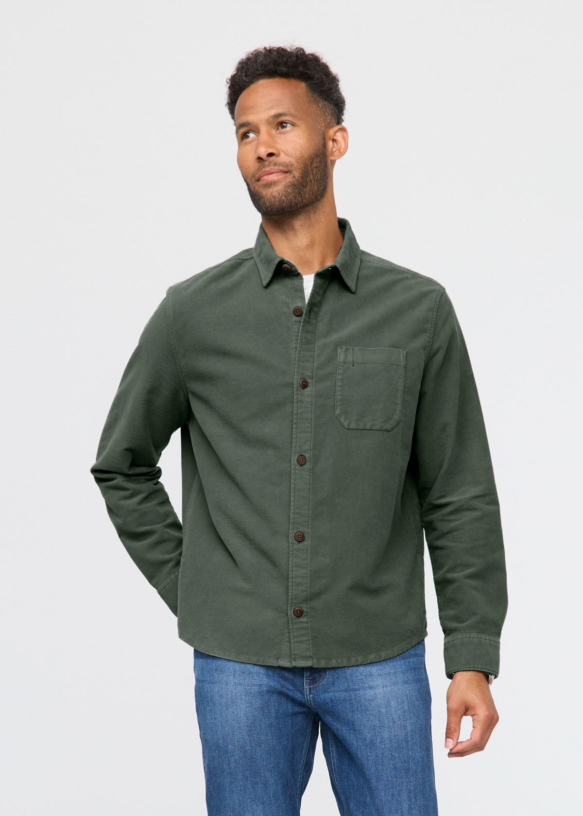 Man wearing a green shirt and blue jeans on a white background By Duer Jeans