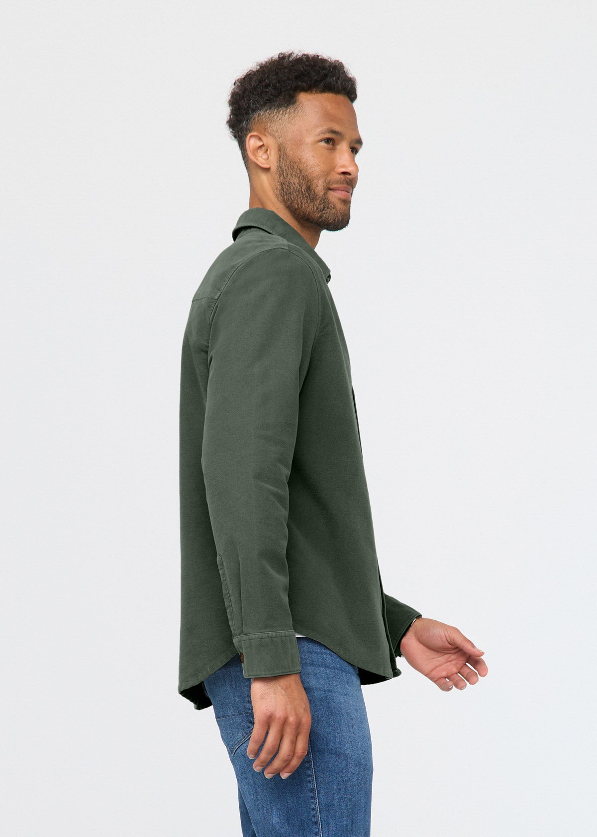Man wearing a green shirt and blue jeans on a white background By Duer Jeans