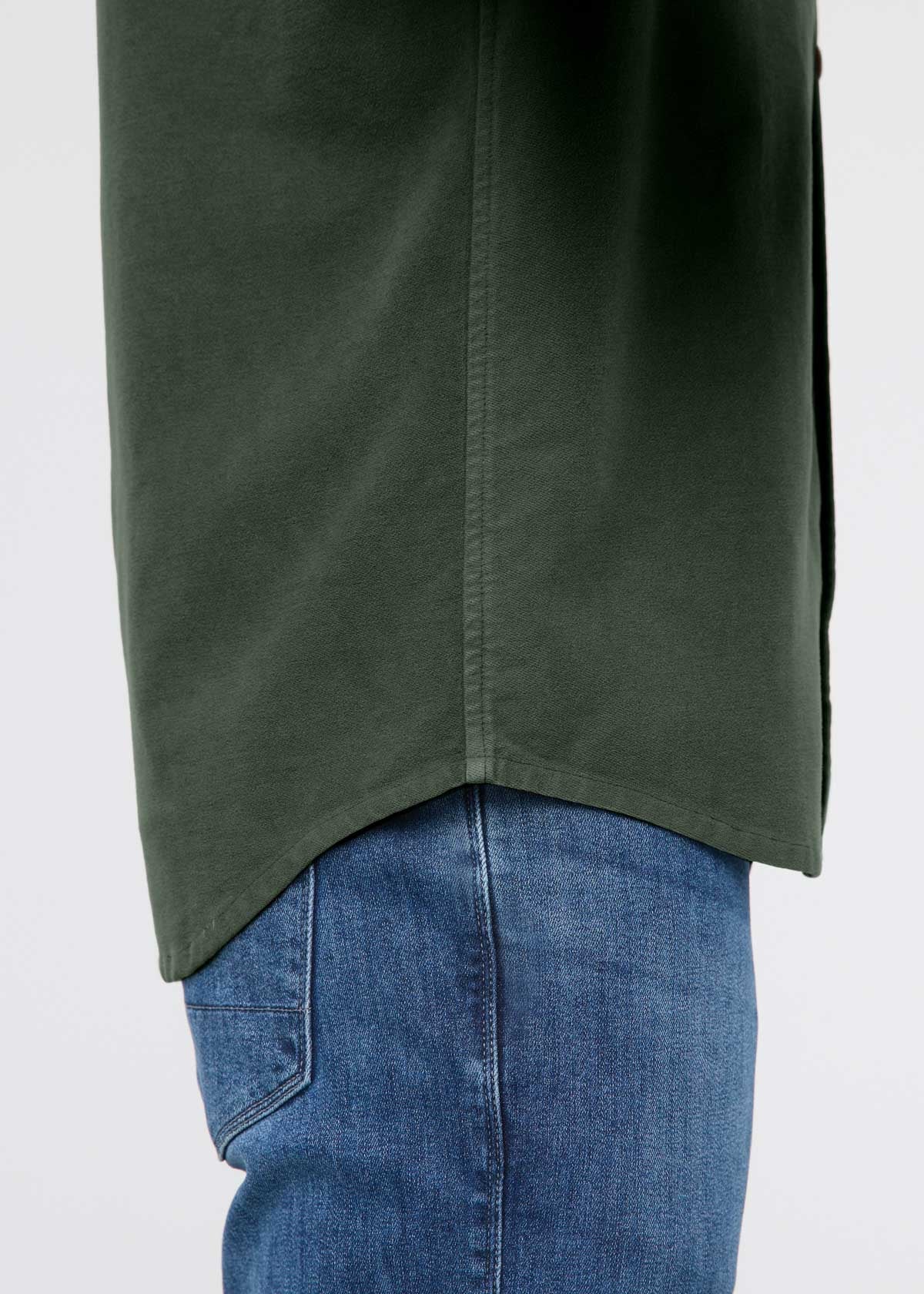 Green shirt over blue jeans on a white background By Duer Jeans