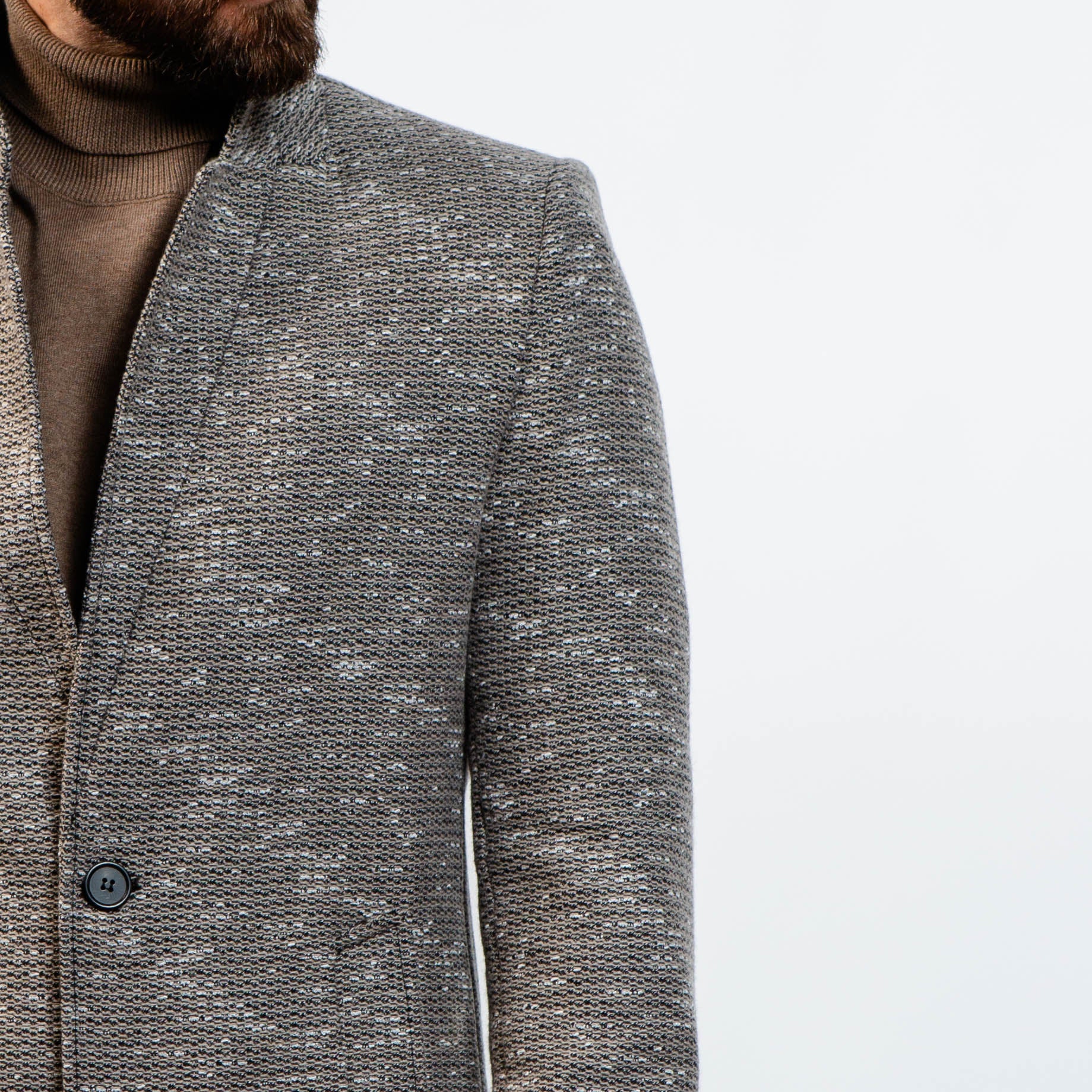 Modern grey wool peacoat layered over brown turtleneck