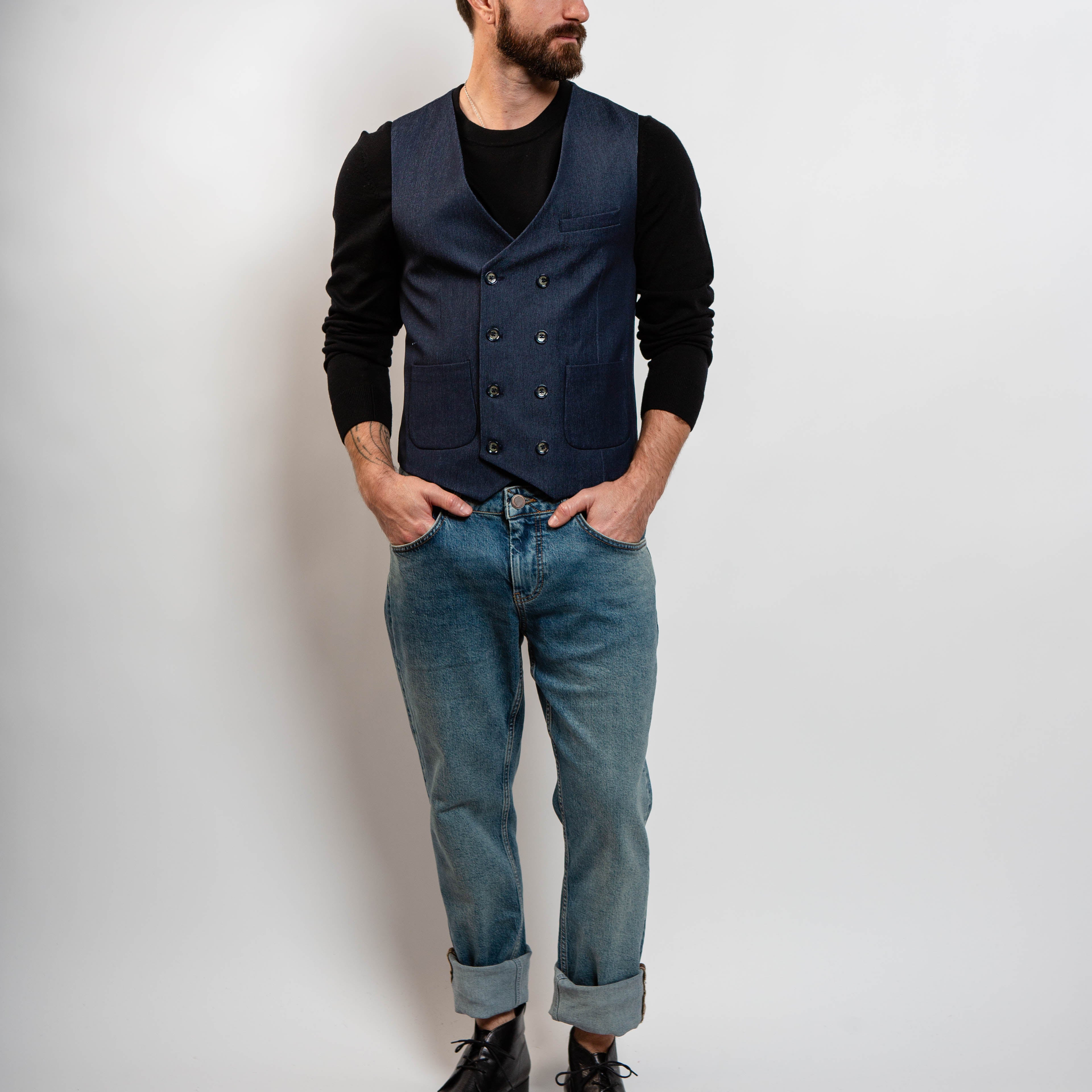 Modern men’s navy vest layered over black sweater