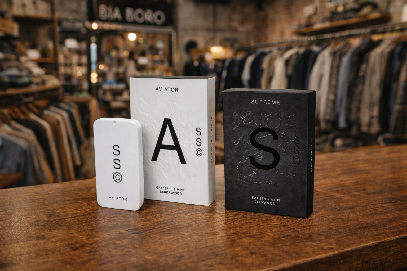 two solid colognes displayed on a wooden counter at bia boro menswear with retail interior in the background