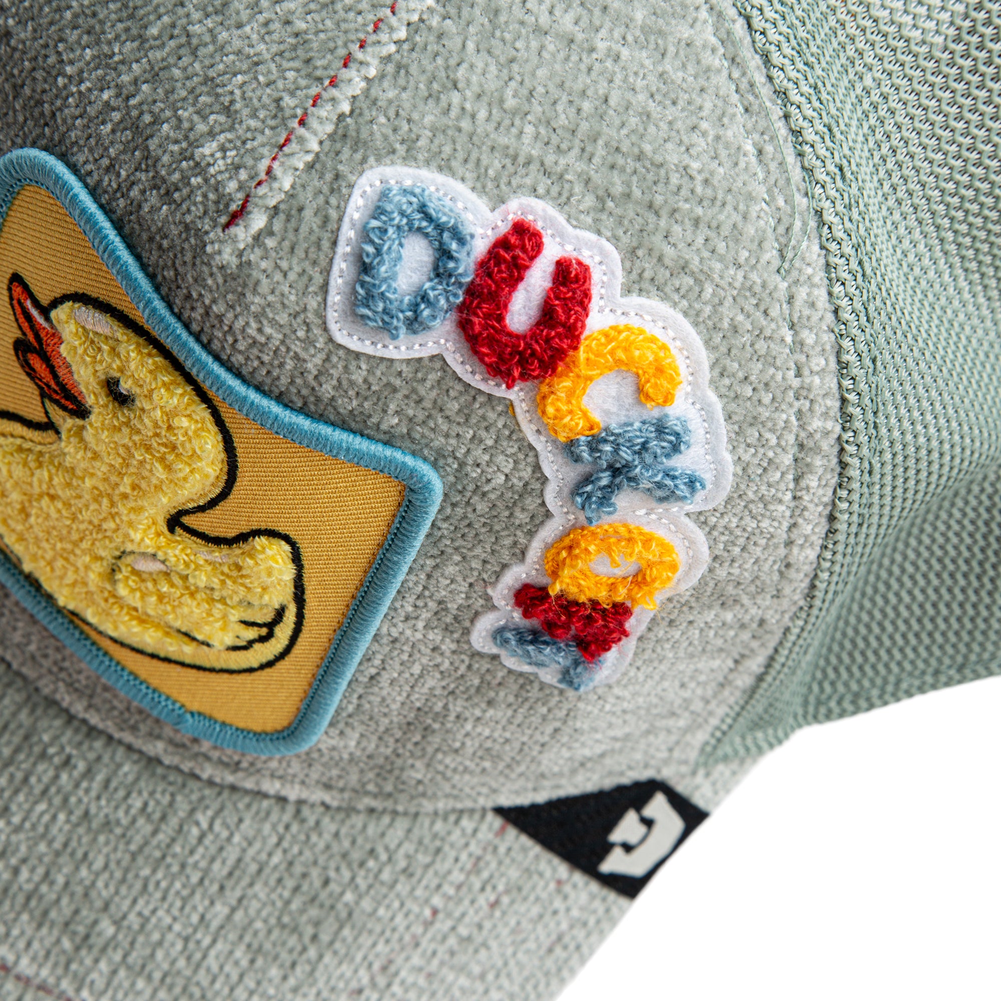 Gray cap with colorful patches including a duck and letters.