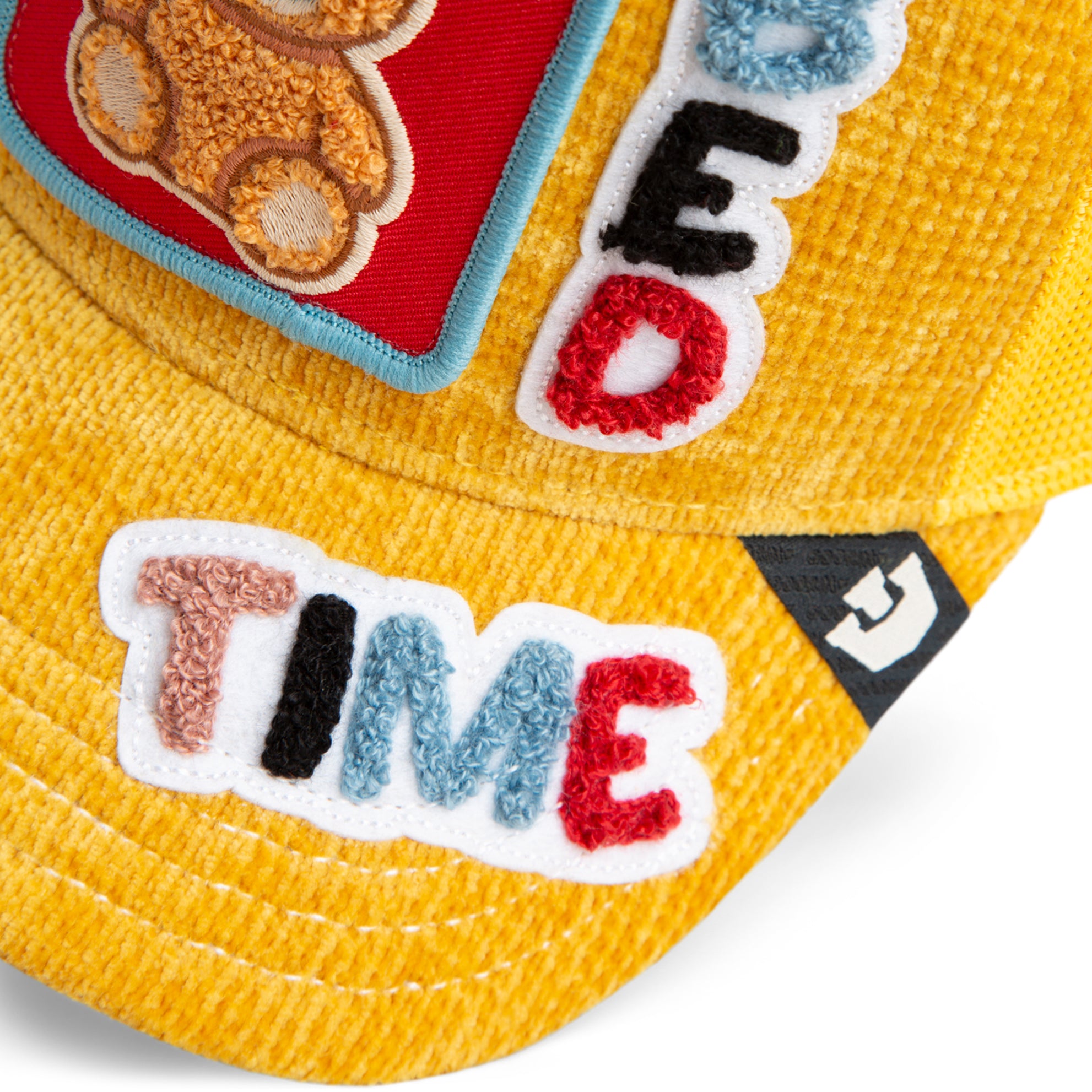 Yellow mesh back corduroy hat featuring teddy bear front patch