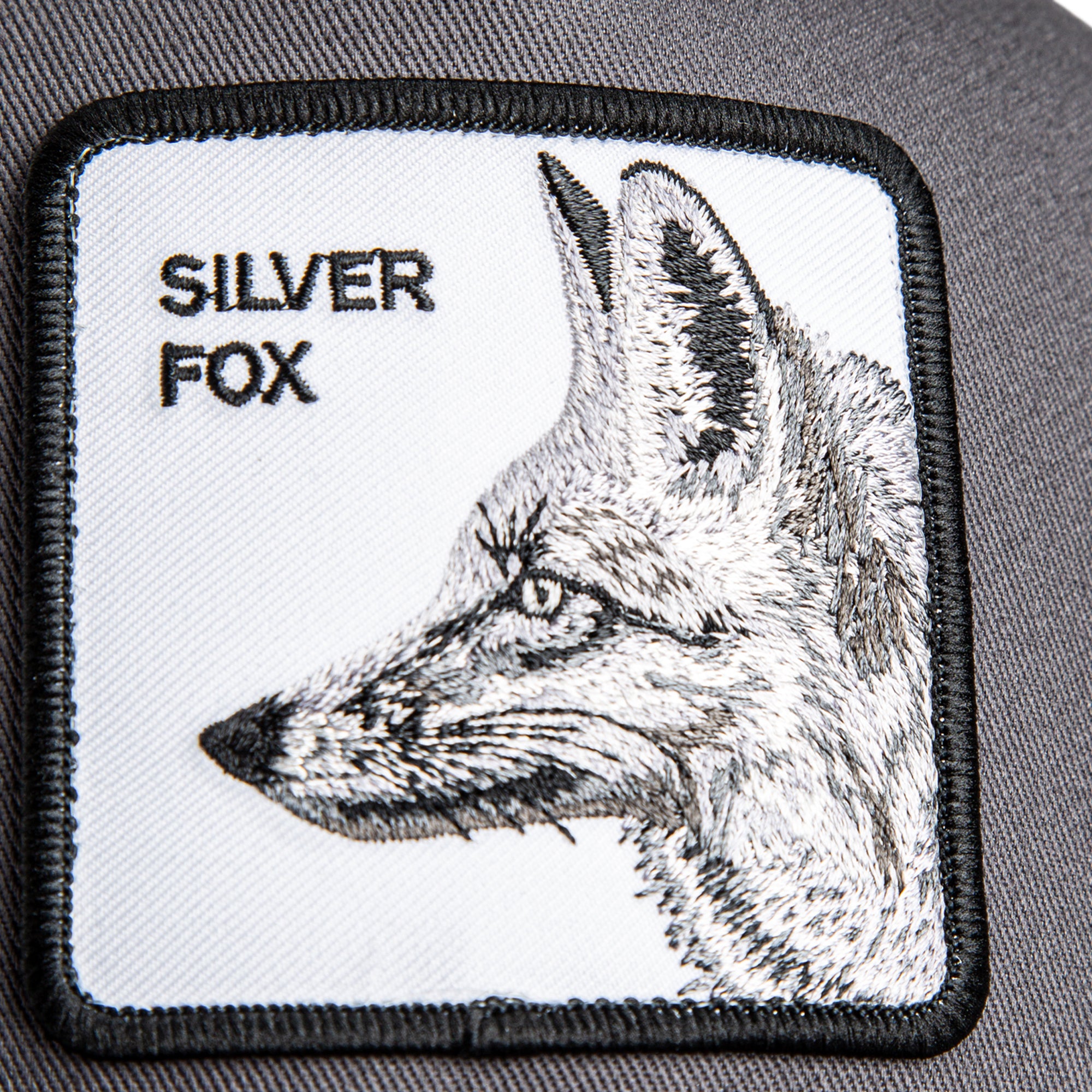 Grey Goorin Bros trucker hat with mesh back featuring embroidered fox patch labeled SILVER FOX on front panel
