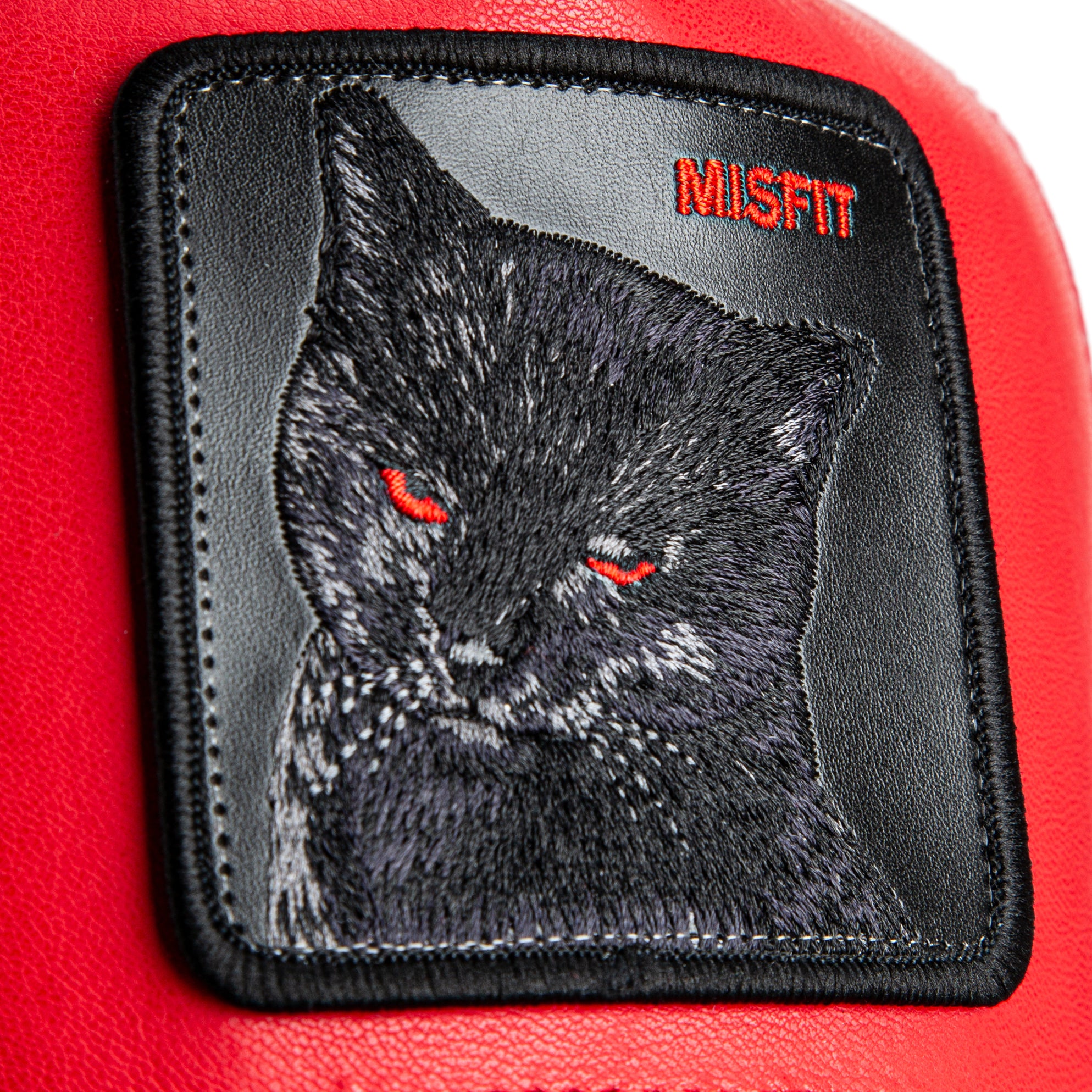 Embroidered patch of a black cat with red eyes on a red background, featuring the brand 'MISFIT'.