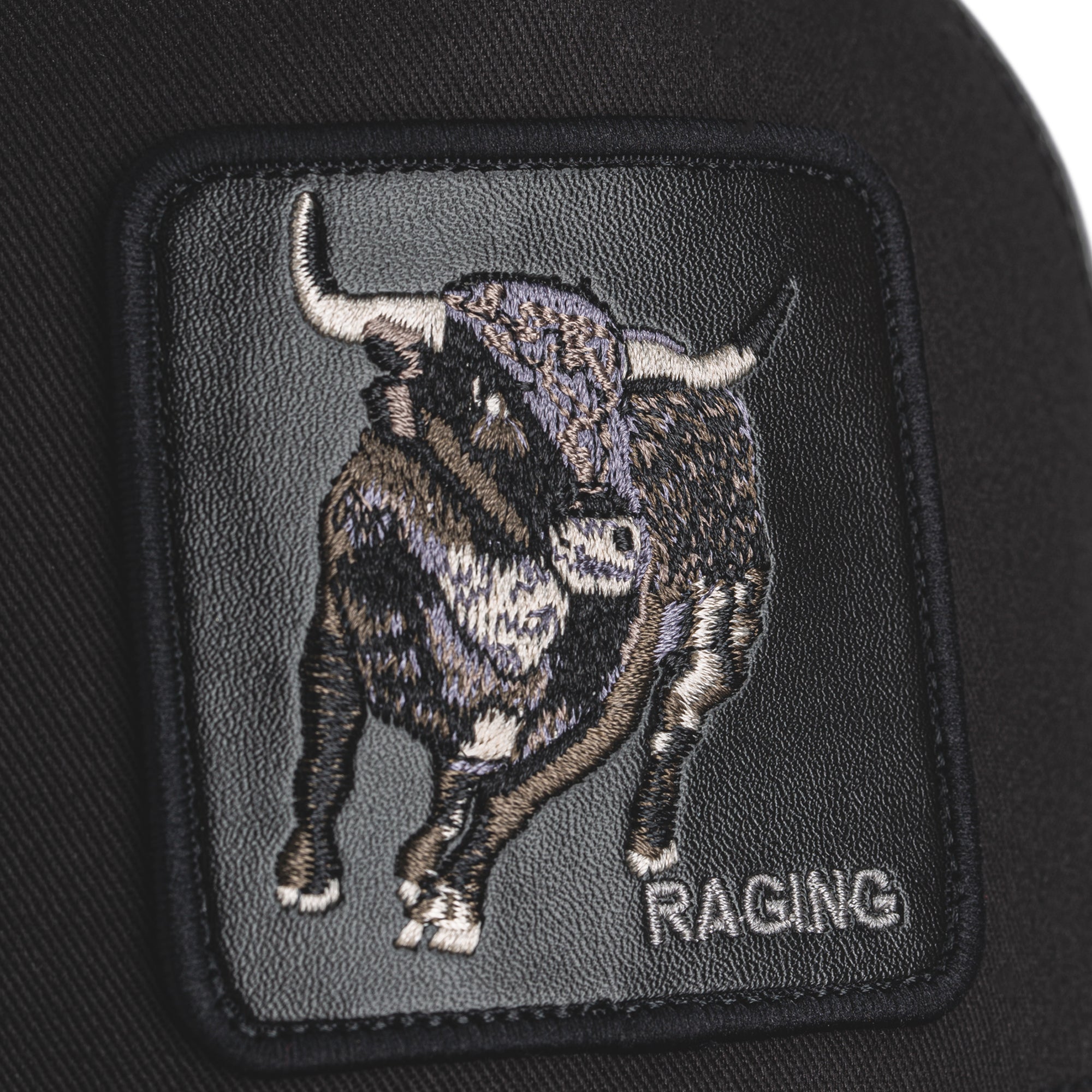 Black Goorin Bros trucker hat with mesh back featuring embroidered bull patch labeled RAGING on front panel
