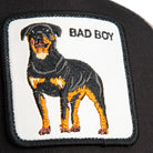 Black and beige Goorin Bros trucker hat with mesh back featuring embroidered Rottweiler patch labeled BAD BOY on front panel
