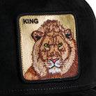 Black cap with a lion patch and 'KING' text on a beige background