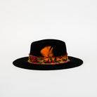 Black hat with colorful feather band on a white background
