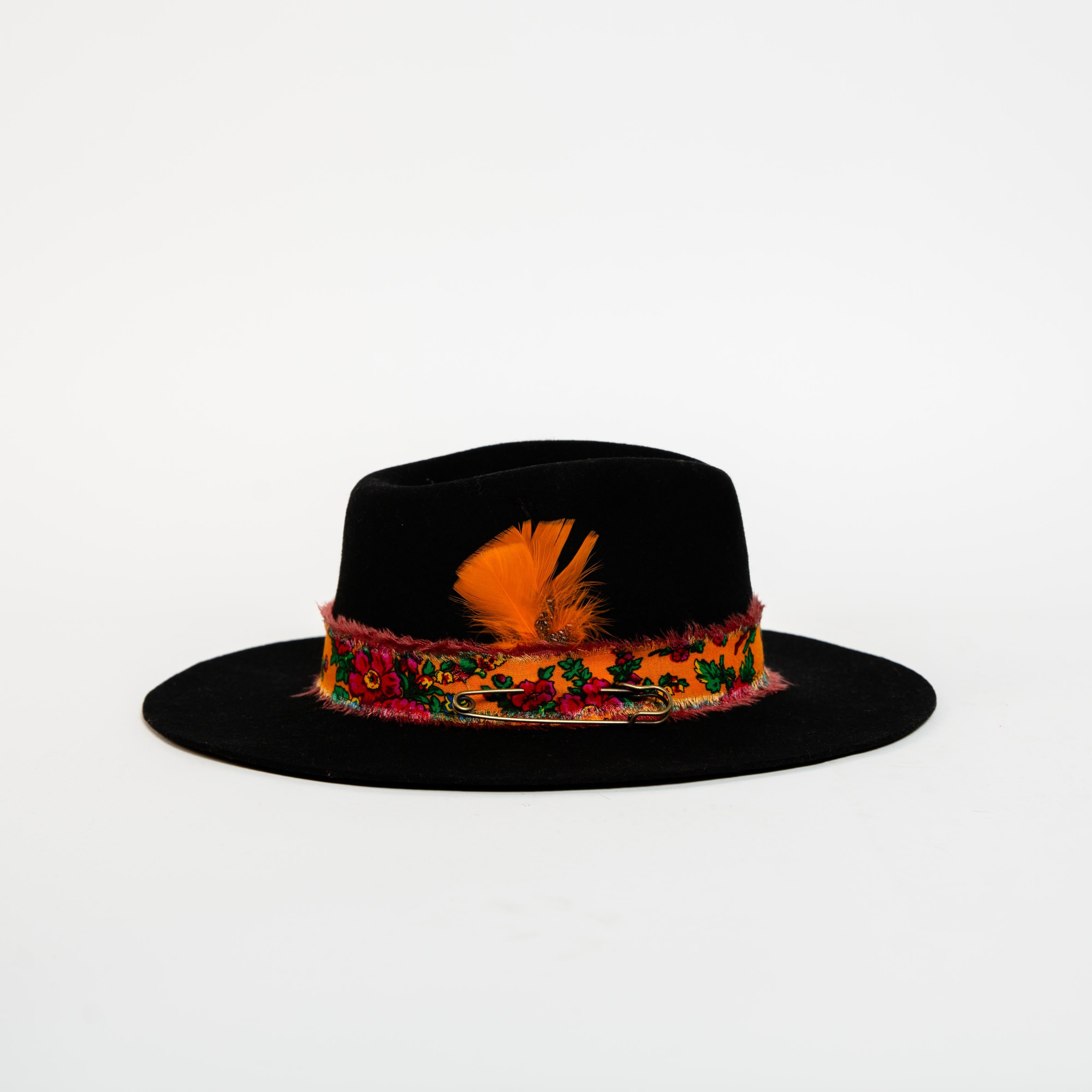 Black hat with colorful feather band on a white background