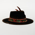 Black hat with a decorative band and feathers on a white background