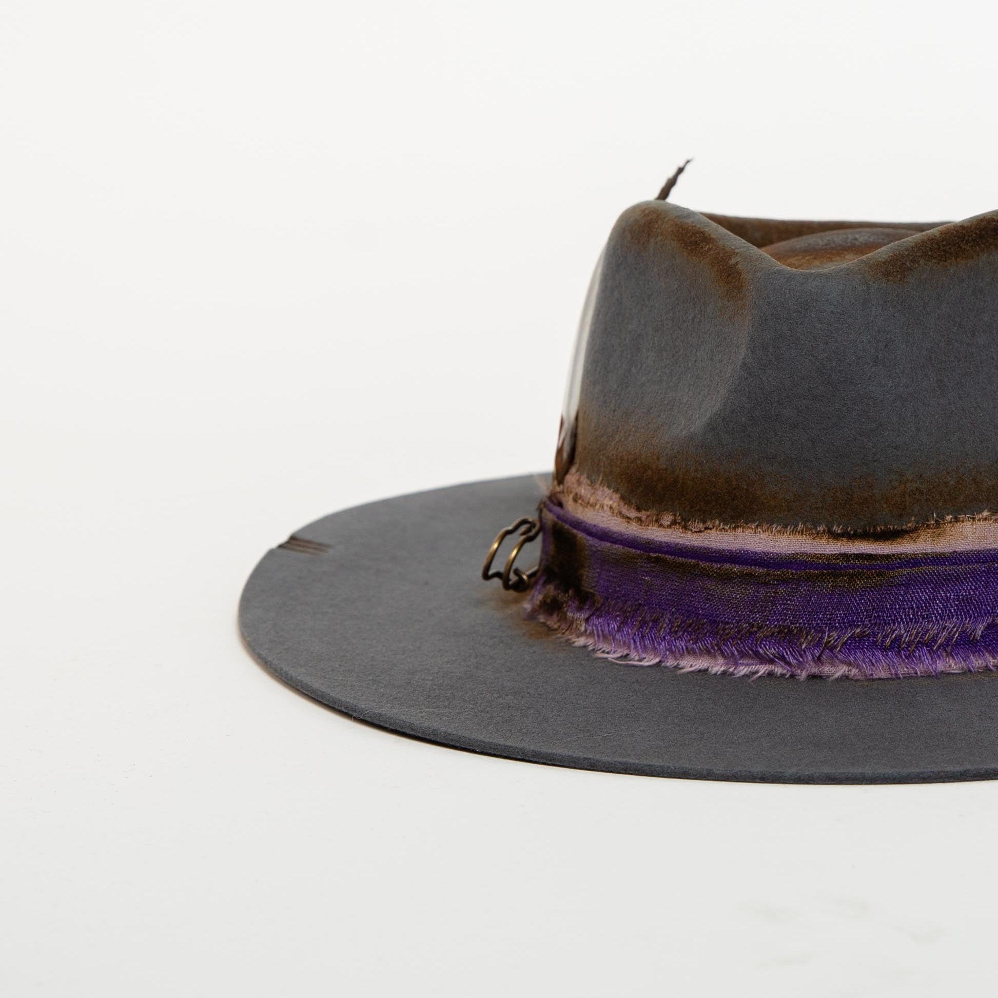 Gray fedora hat with purple band on a white background