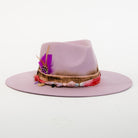 Pink hat with decorative band on a white background