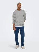 Man wearing a gray sweater and blue jeans on a white background By Only & Sons