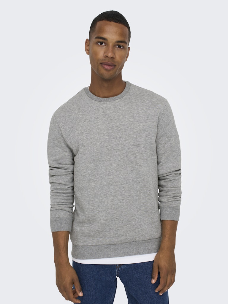 Man wearing a gray sweatshirt and blue jeans on a white background By Only & Sons