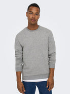 Man wearing a gray sweatshirt and blue jeans on a white background By Only & Sons