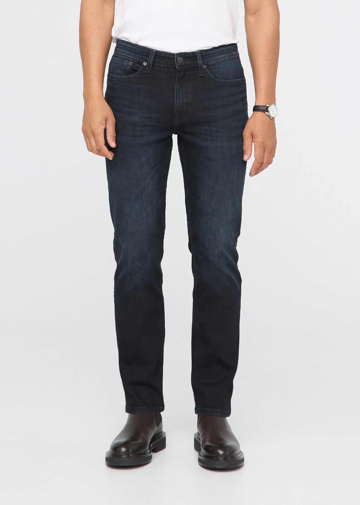 Person wearing dark blue jeans on a white background By Duer Jeans