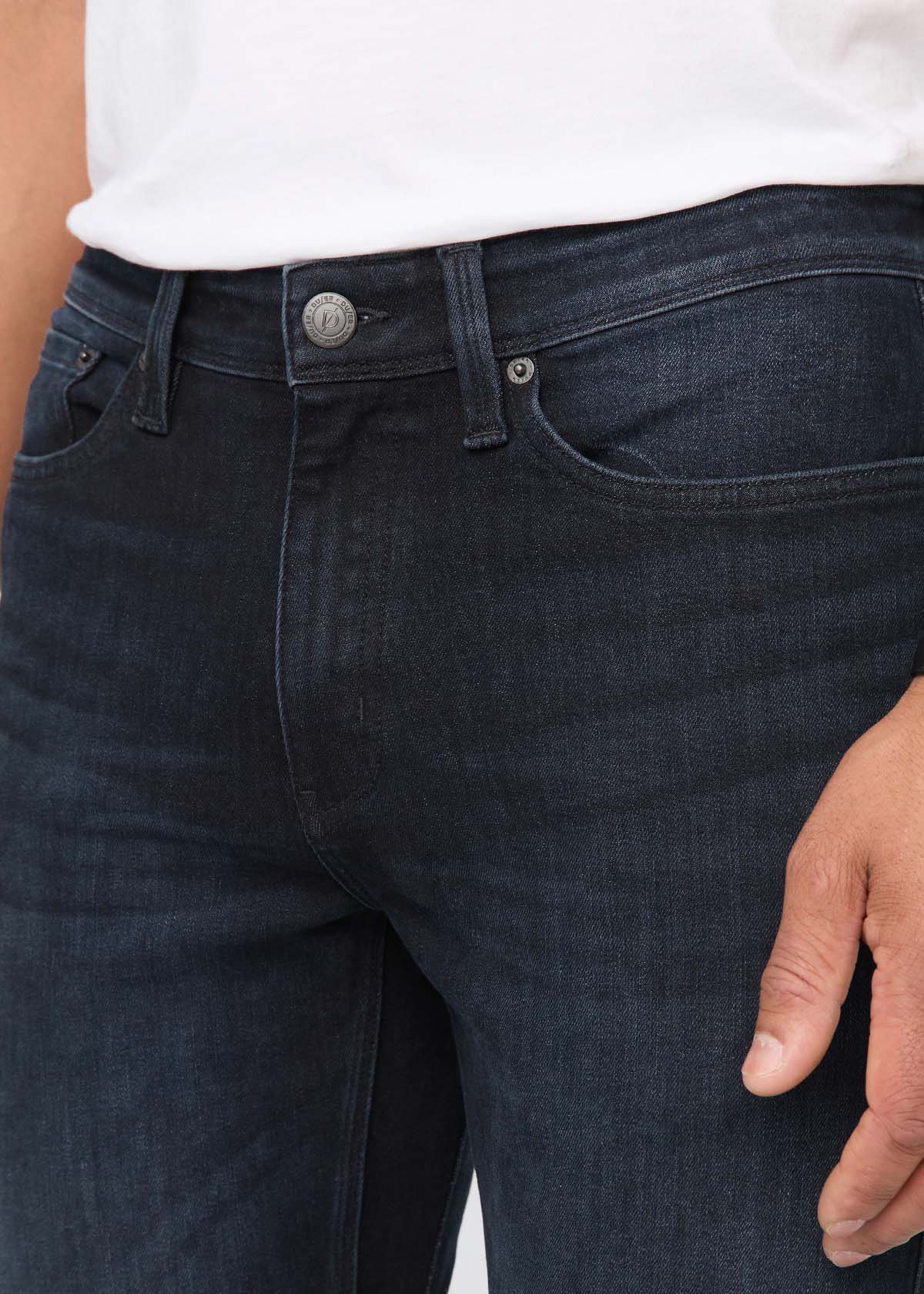 Close-up of dark blue jeans with a white shirt underneath By Duer Jeans