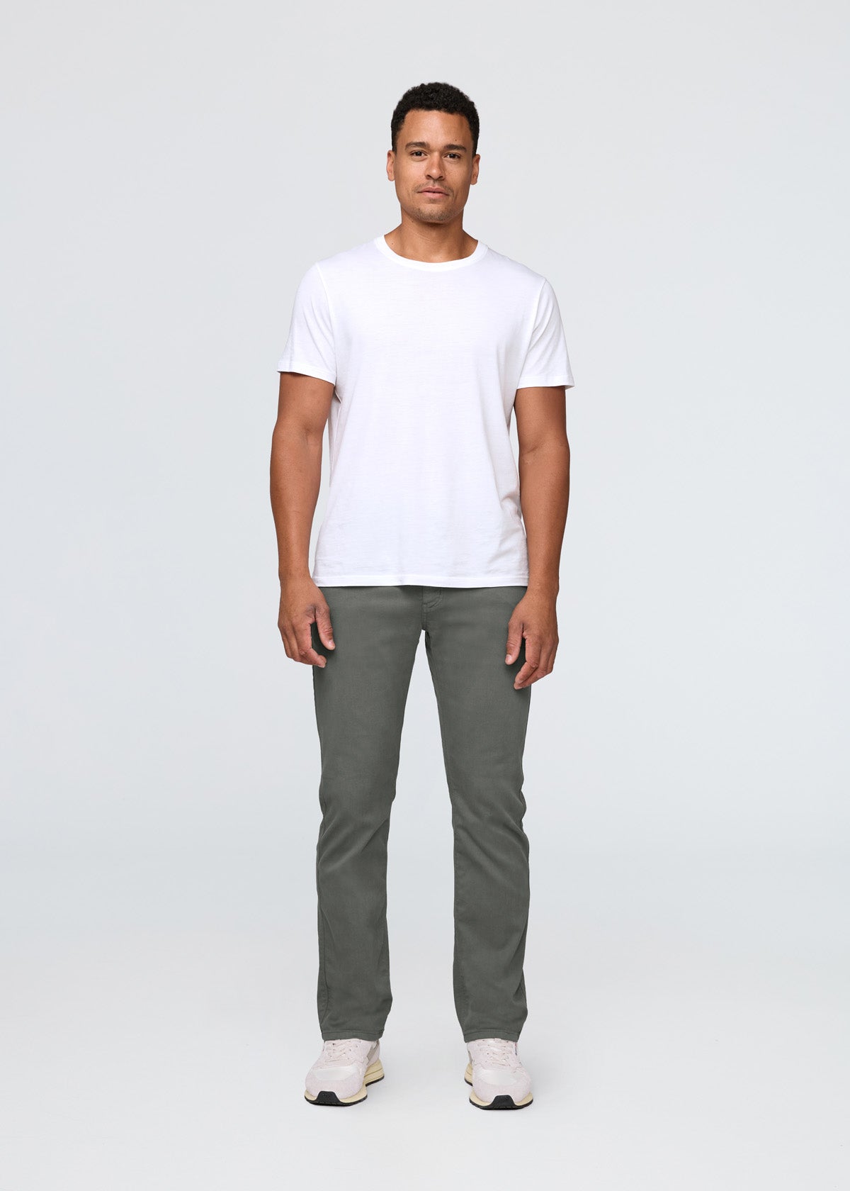 Man wearing a white t-shirt and gray pants on a white background By Duer Jeans