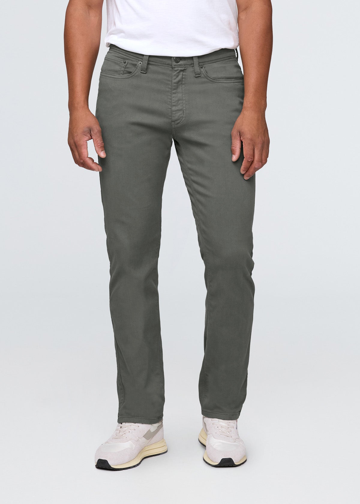 Person wearing gray pants and white sneakers on a white background By Duer Jeans