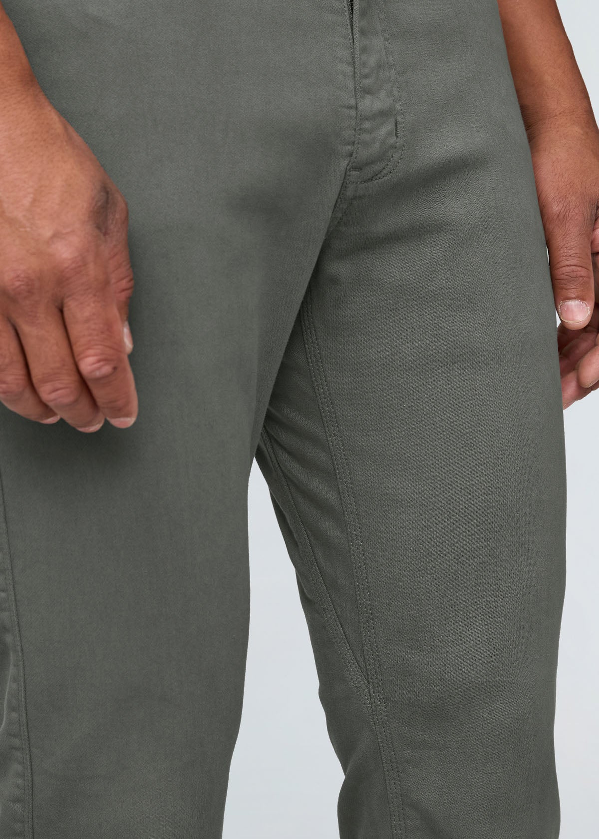 Close-up of a person wearing gray pants on a light gray background By Duer Jeans