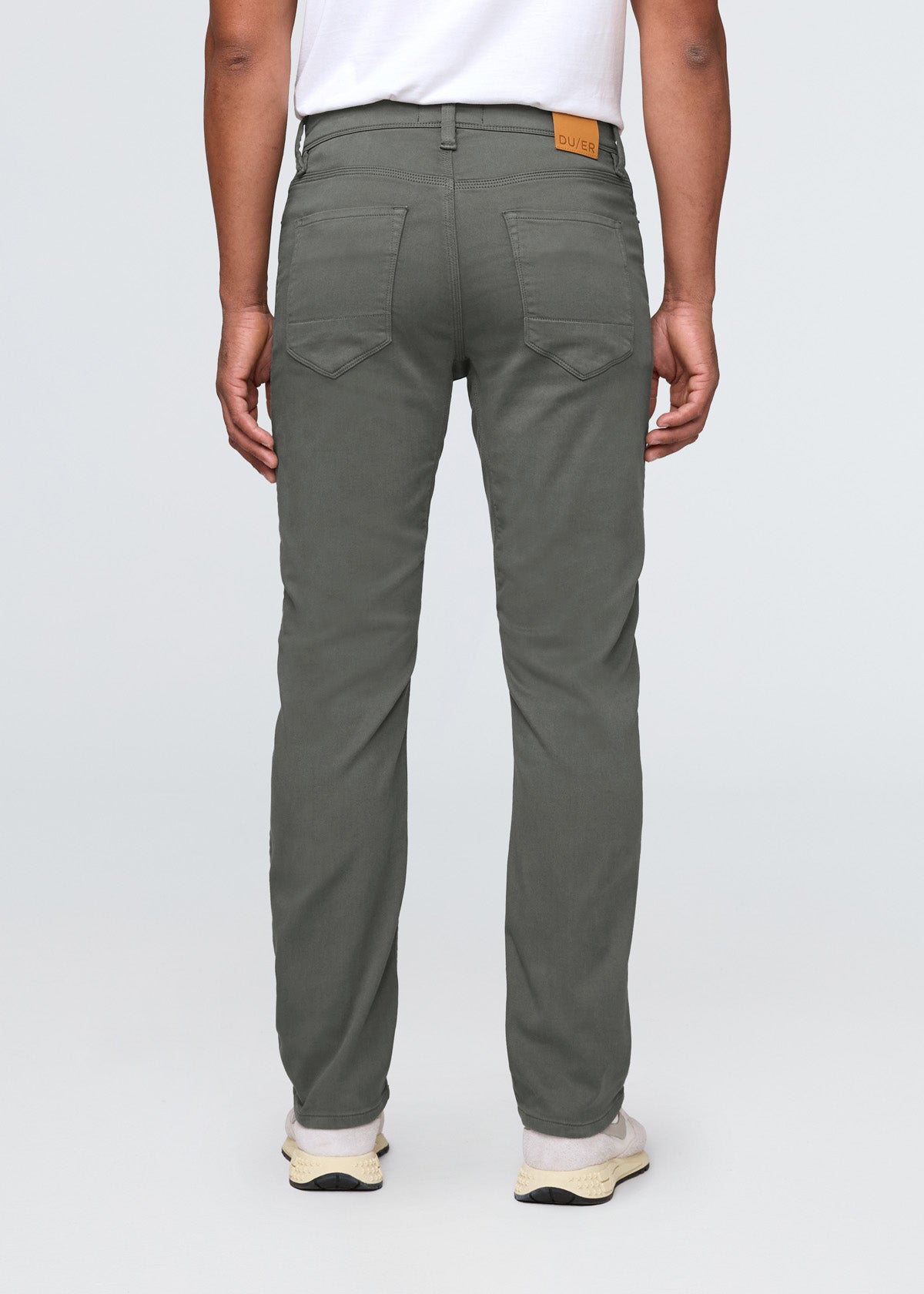 Person wearing green pants on a white background By Duer Jeans