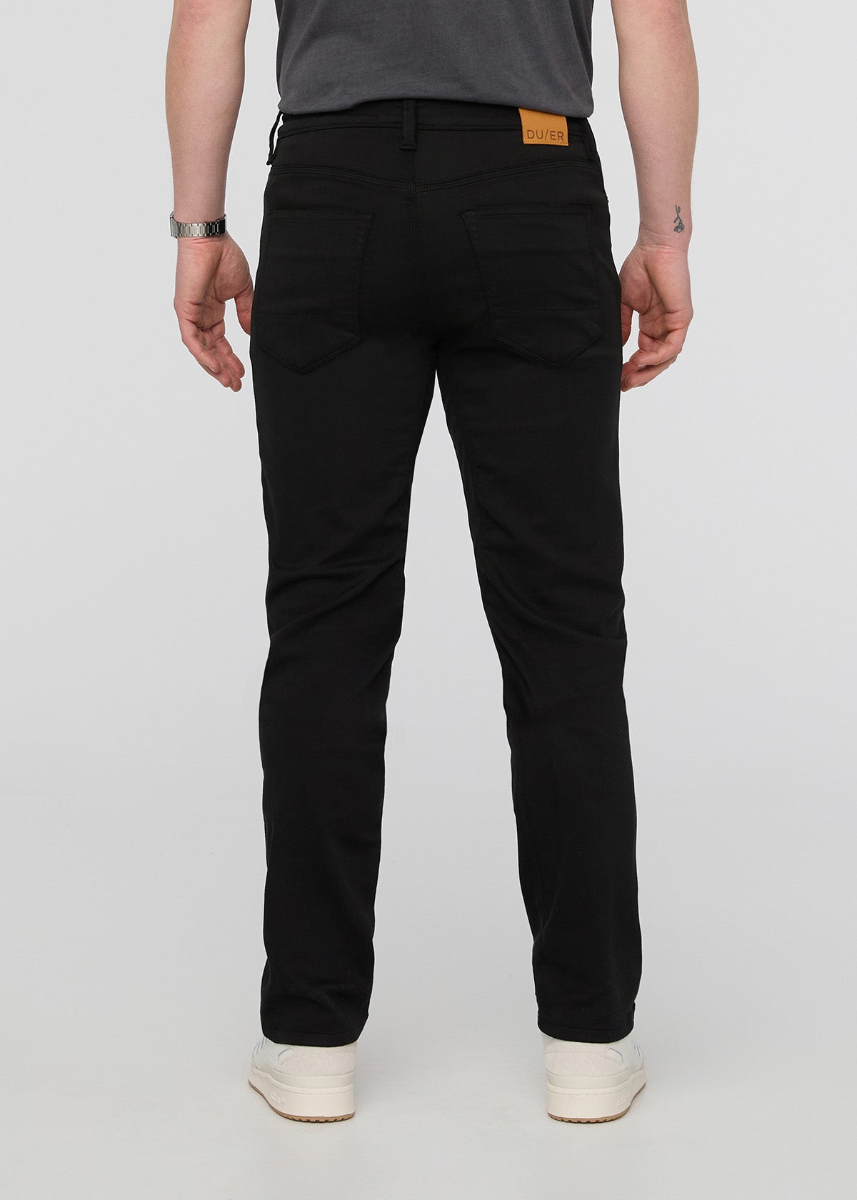 Person wearing black pants on a white background By Duer Jeans