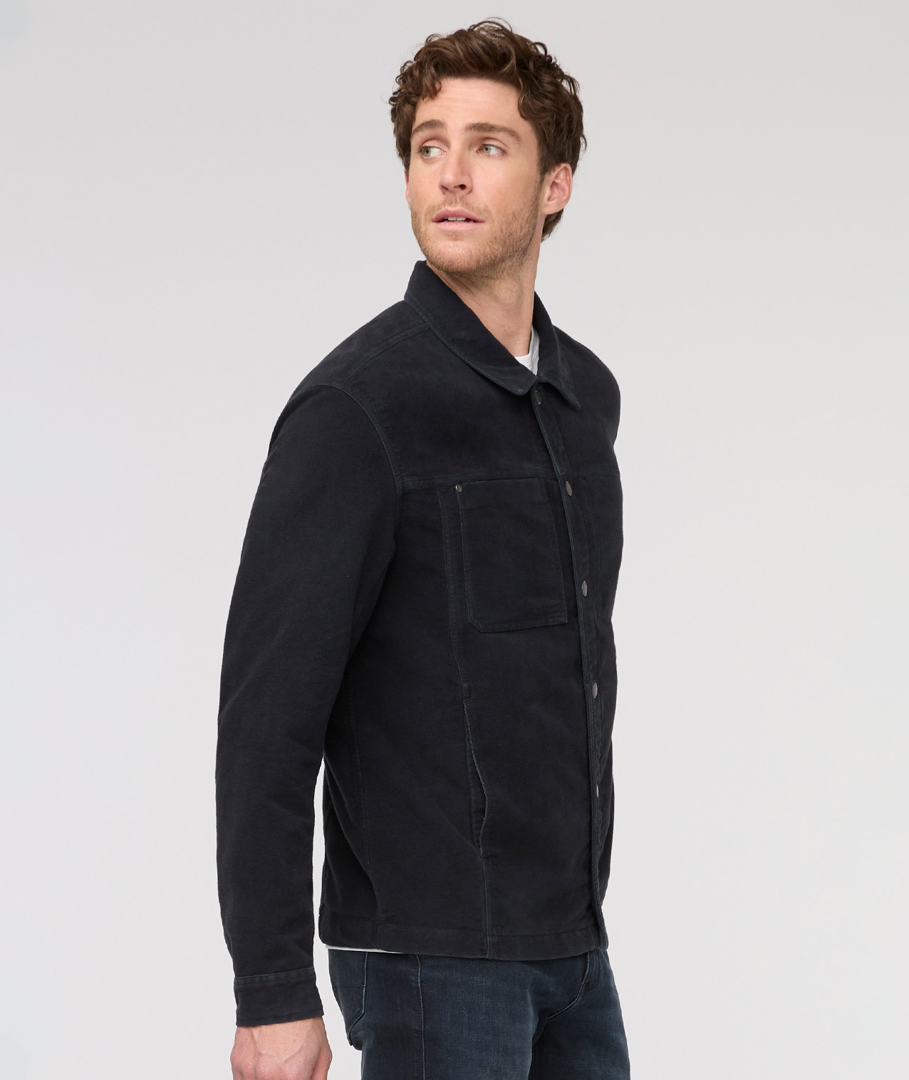 Man wearing a black jacket on a light gray background By Duer Jeans