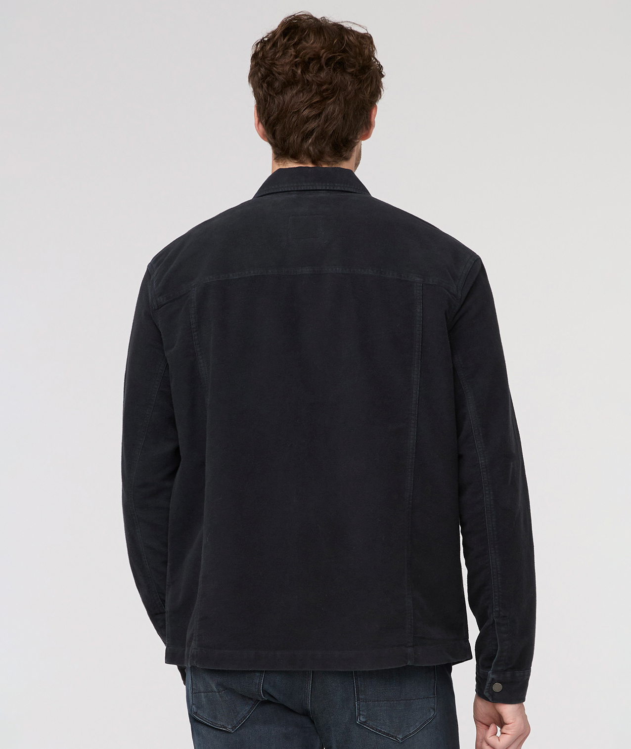Man wearing a black jacket on a light gray background By Duer Jeans