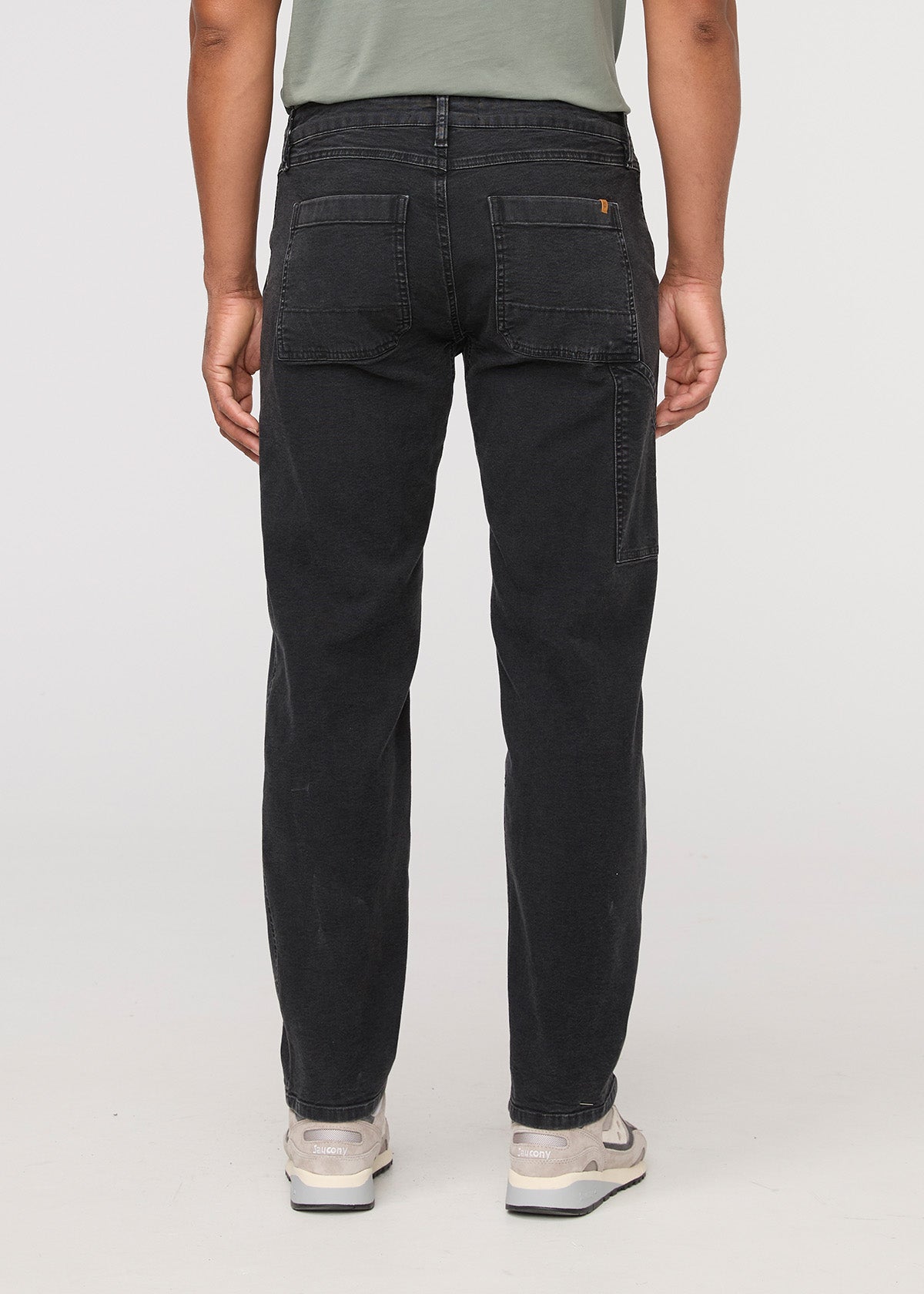 Person wearing black jeans on a white background By Duer Jeans