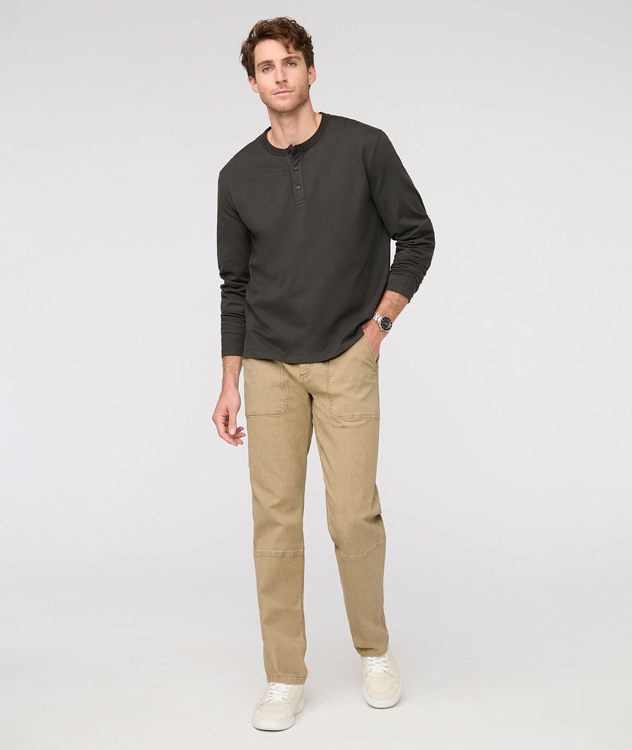 Man wearing a dark green long-sleeve shirt and beige pants on a white background By Duer Jeans