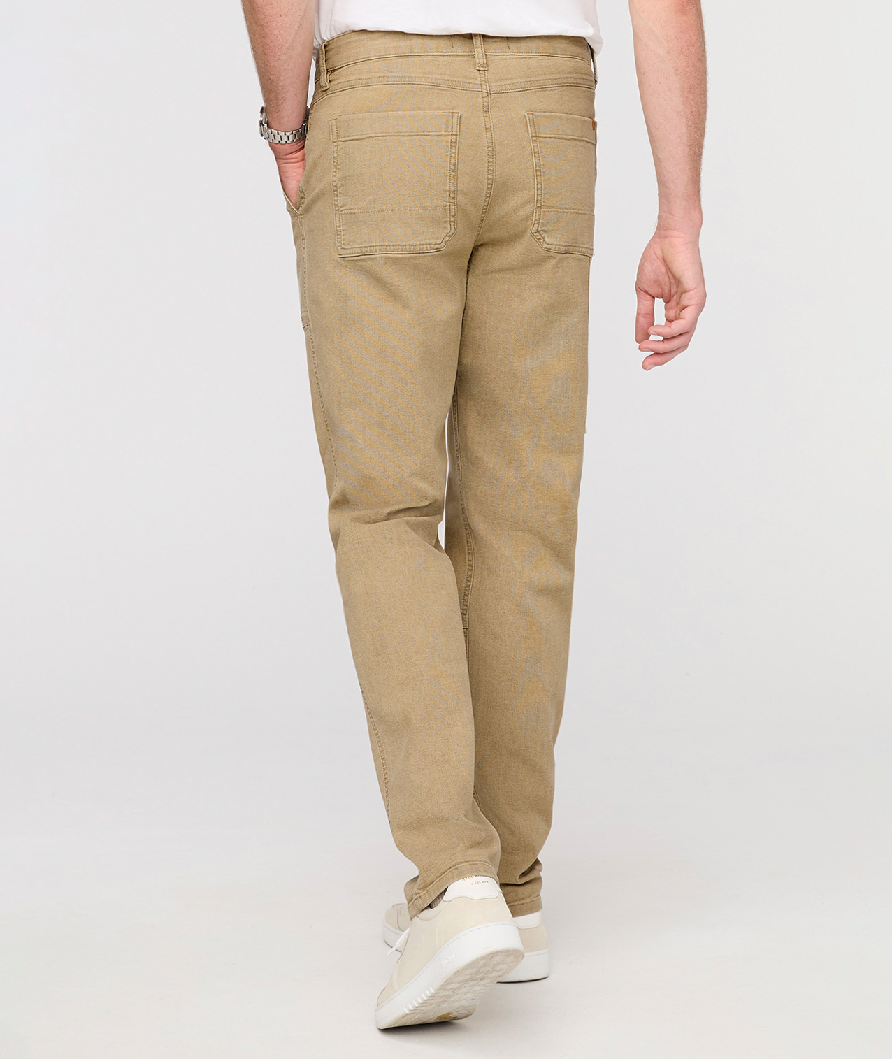 Person wearing beige pants on a white background By Duer Jeans