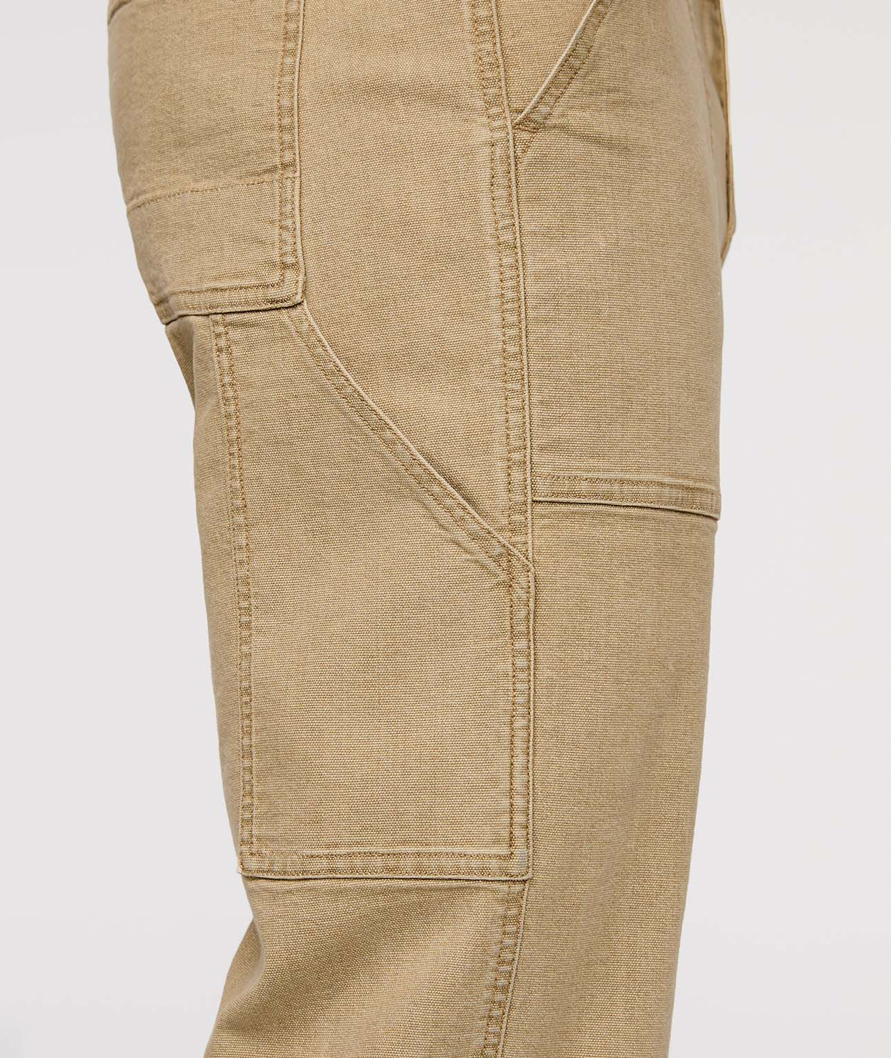 Close-up of beige cargo pants on a white background By Duer Jeans