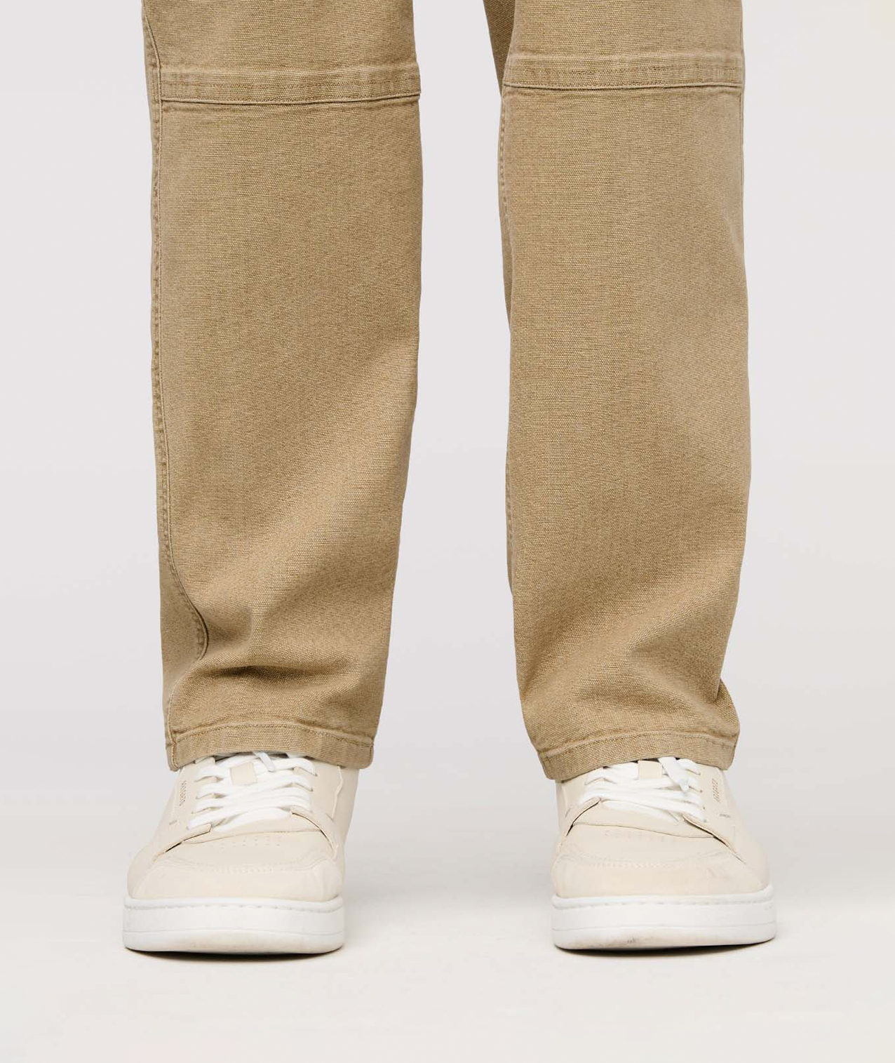 Beige pants worn by a person on a white background By Duer Jeans