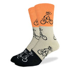Men’s color-block crew socks in orange, beige, and black with playful dog riding a bicycle pattern, available at Bia Boro boutique in Vancouver